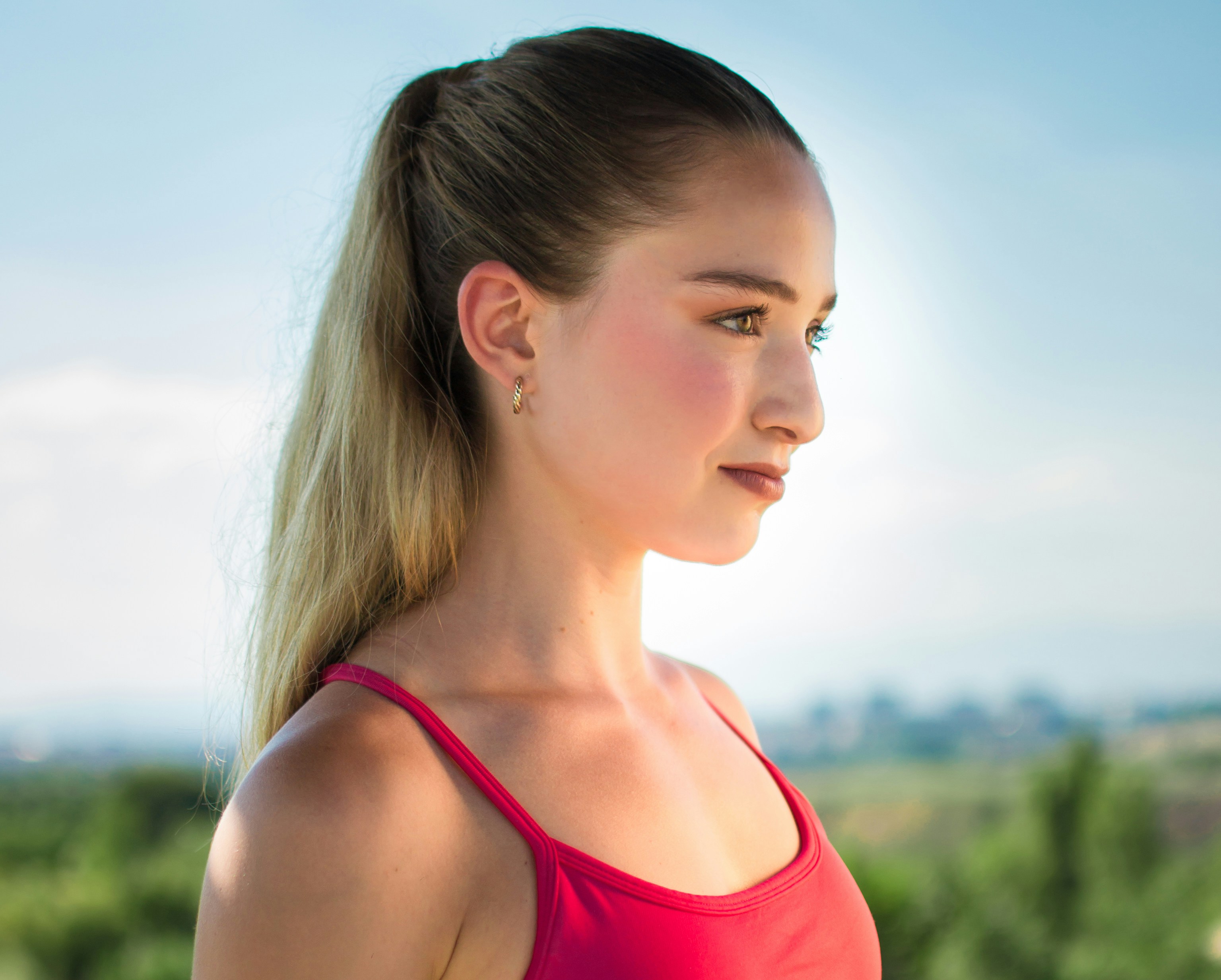 Young woman with blonde ponytail in red top