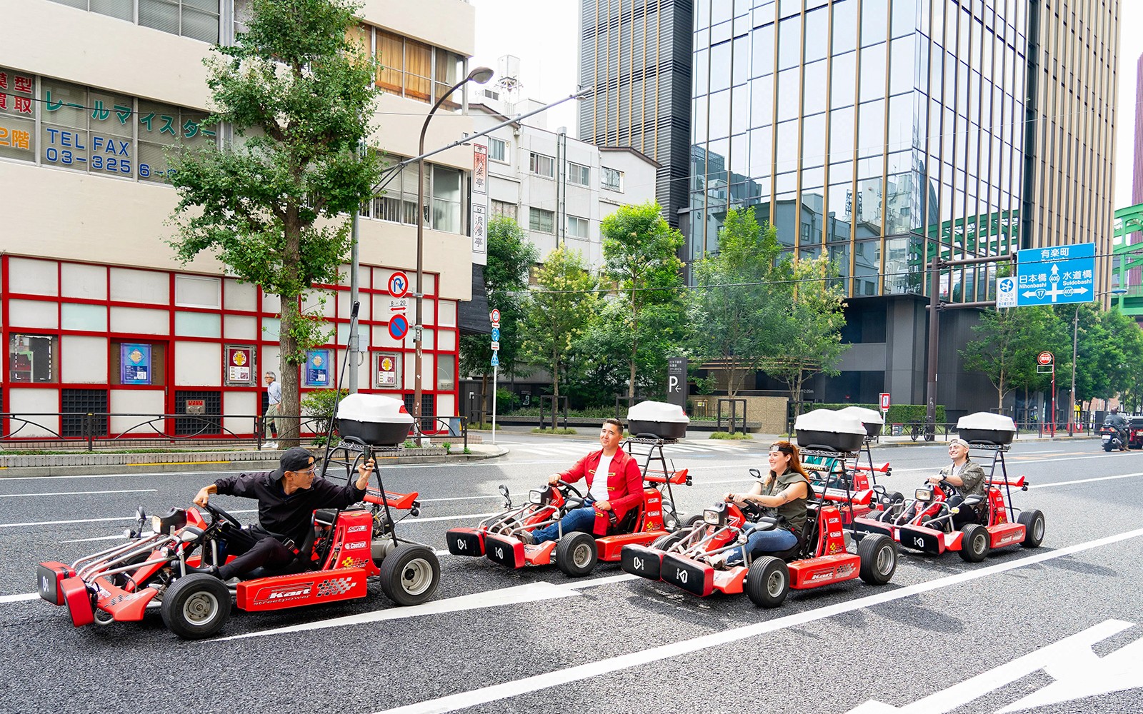 在東京秋葉原的城市景觀背景下,團體駕駛卡丁車。