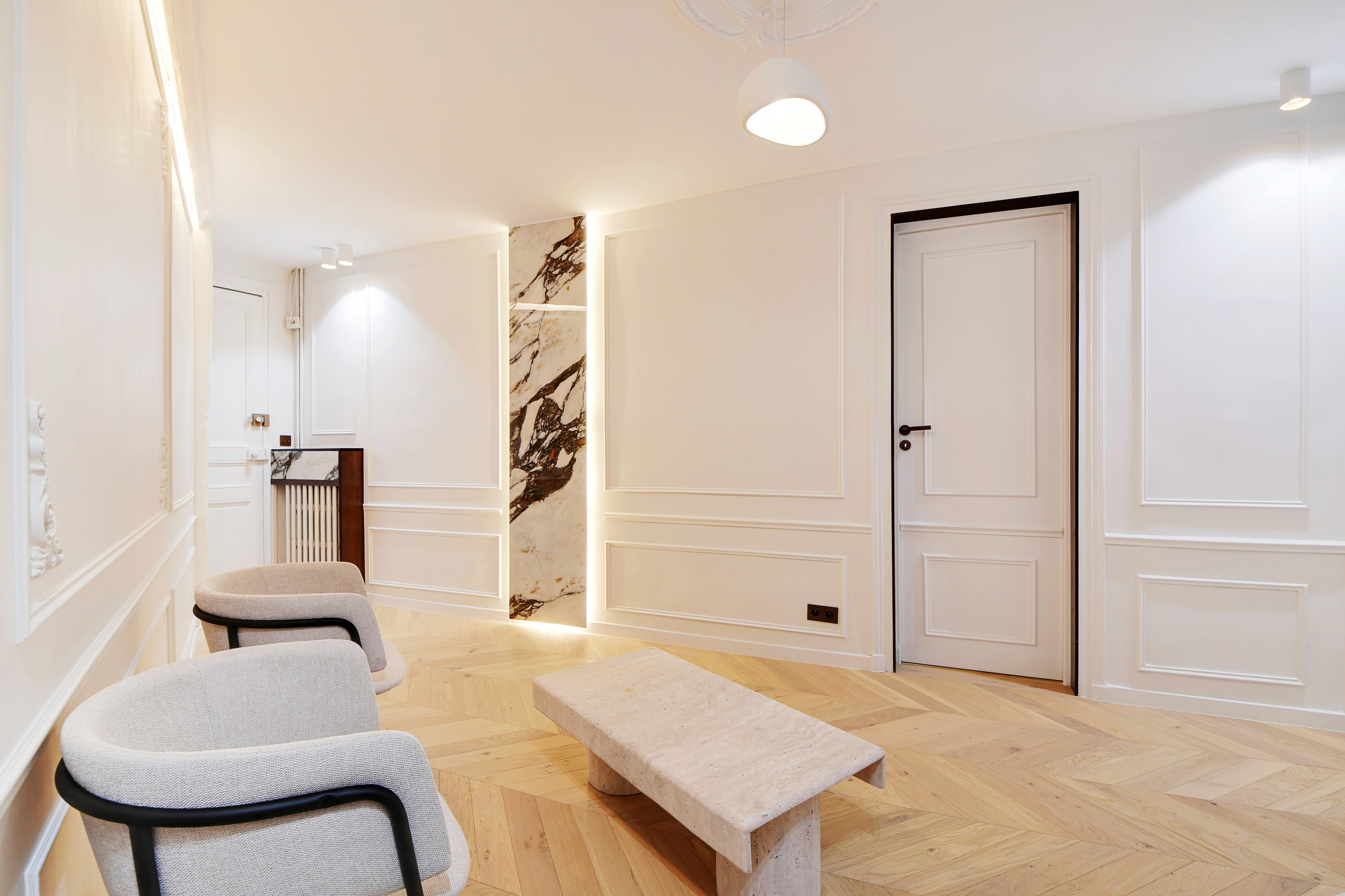 Close-up of a woman's hands adorned with rings and layered necklaces, highlighting her smooth skin and elegant jewelry