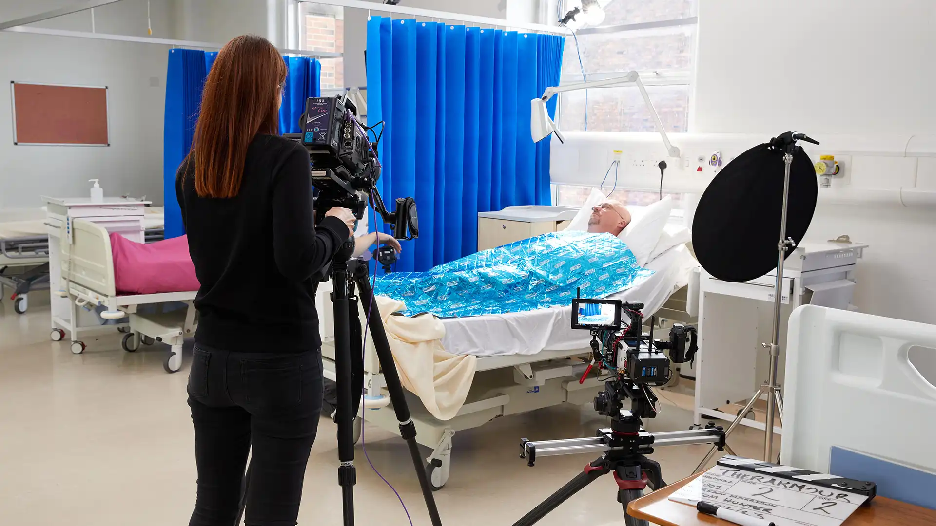 Group of presenters speaking on camera during a Microsoft live broadcast, filmed against branded event graphics.