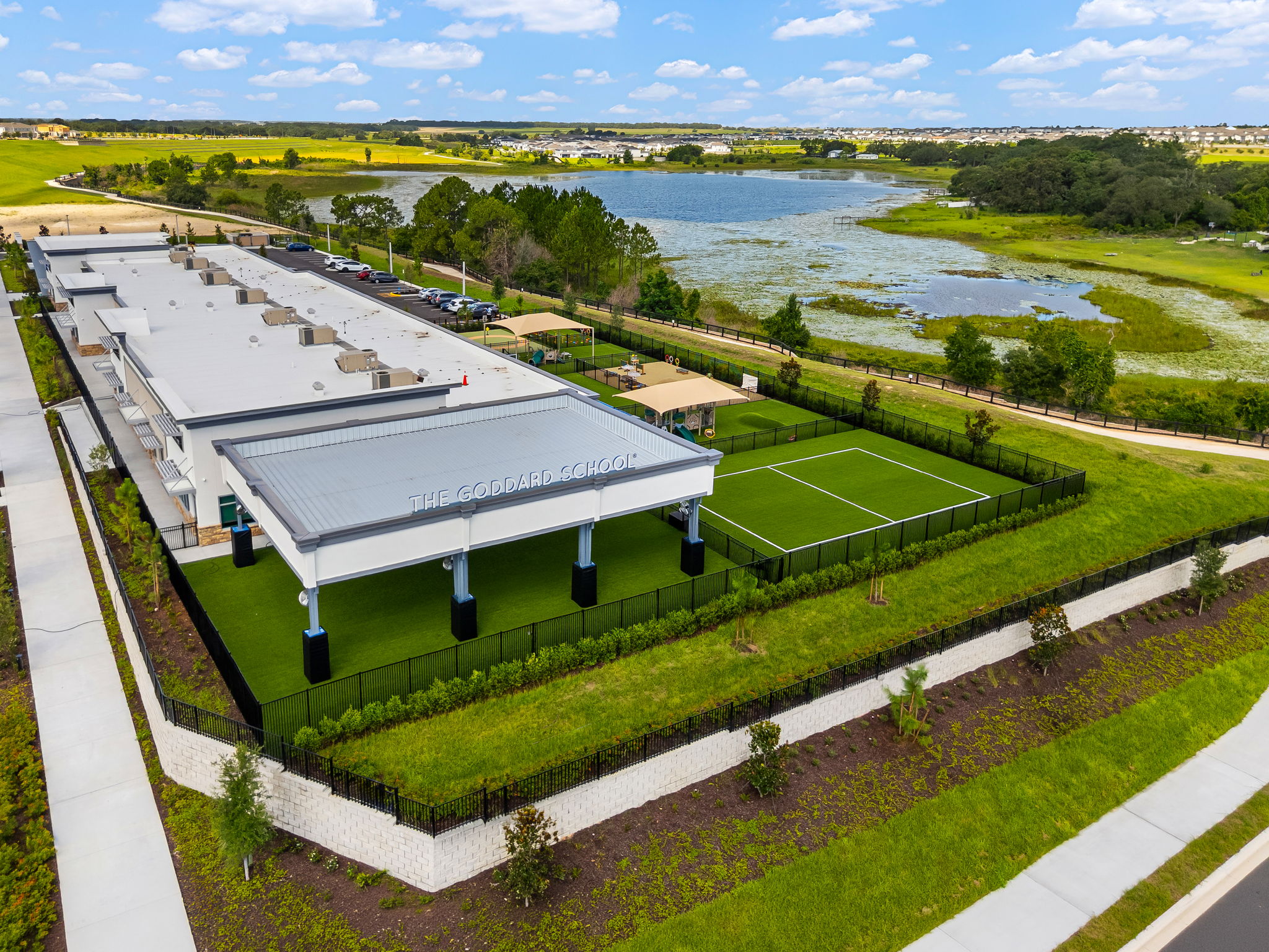 Aerial view of The Goddard School playground, sports field and lake in Winter Garden, Florida