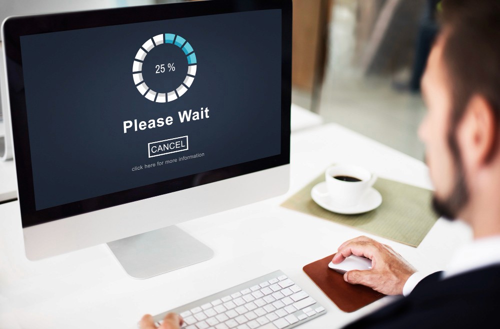 A man seating in front of a computer with a app loading screen
