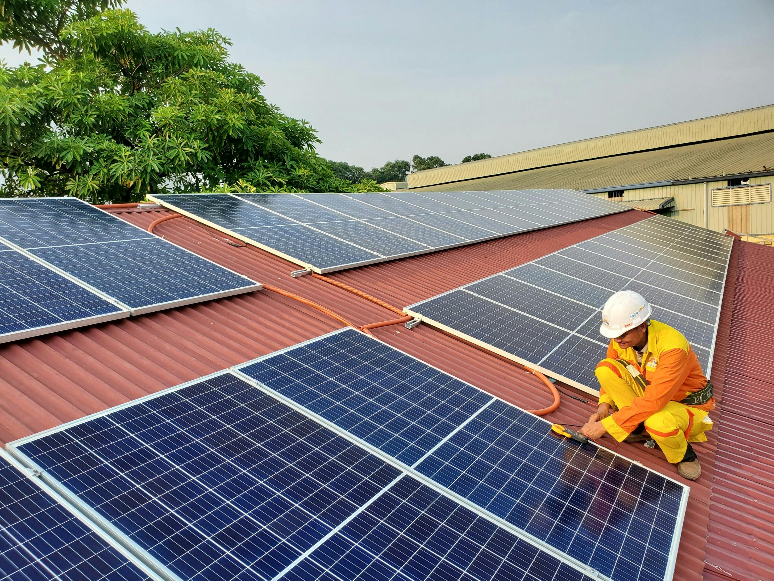 Technician working on solar panels on a red roof