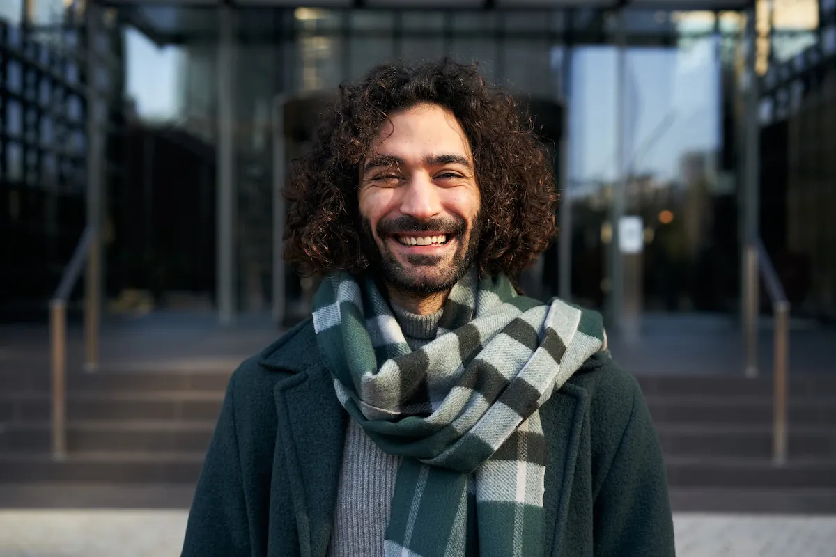 Smiling man wearing a scarf and coat