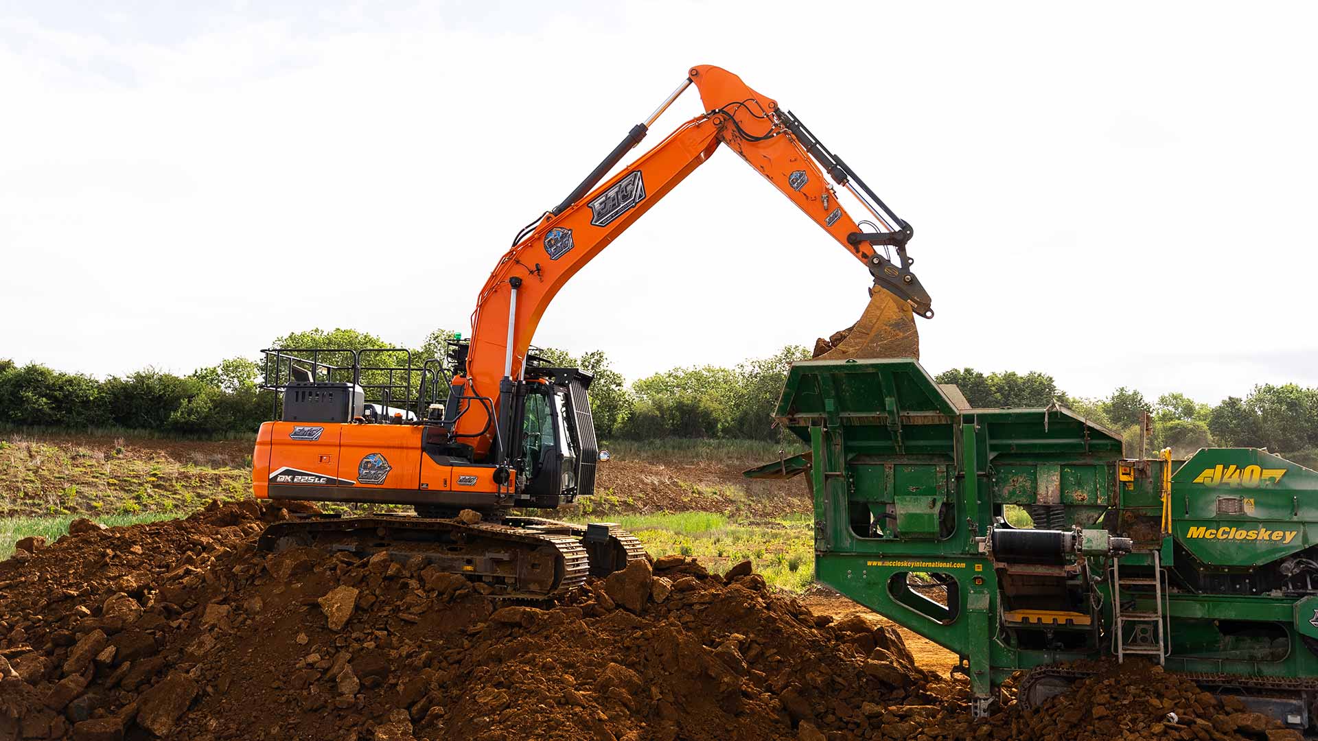 ETC excavator loading soil into McCloskey crusher during large-scale remediation and earthworks operation