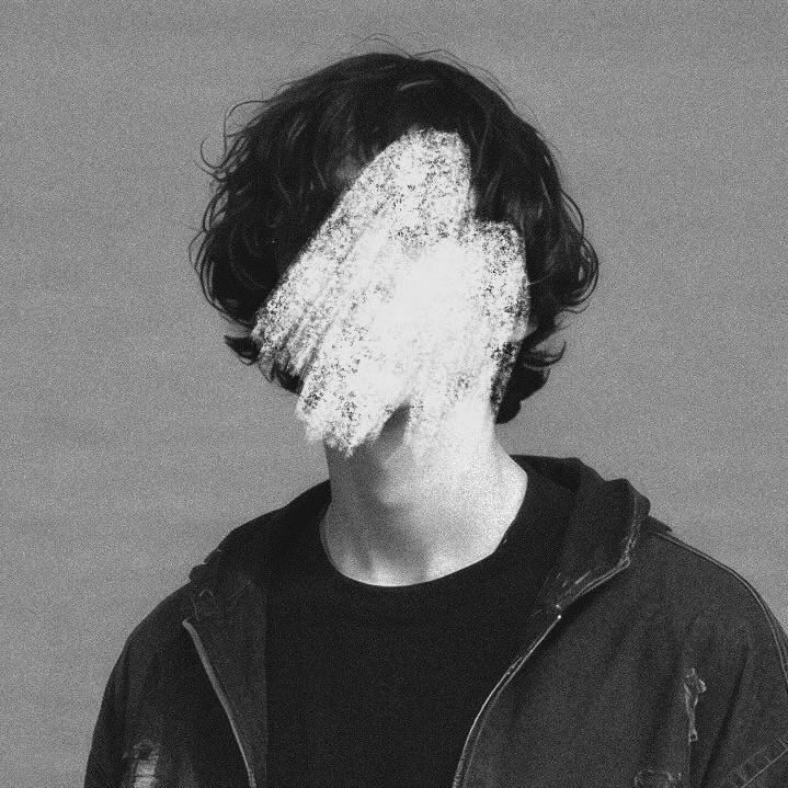 Portrait of a laughing person with curly hair wearing a white shirt