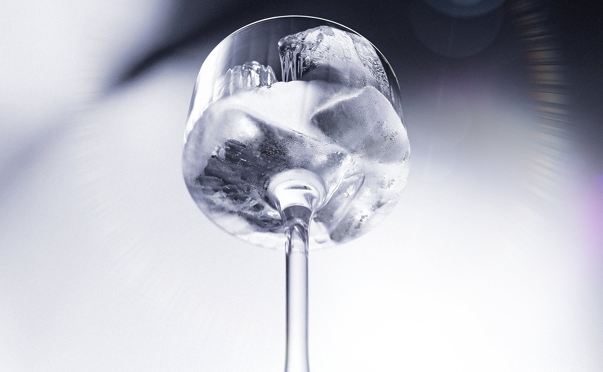 A close-up of a glass full of ice against a light background.