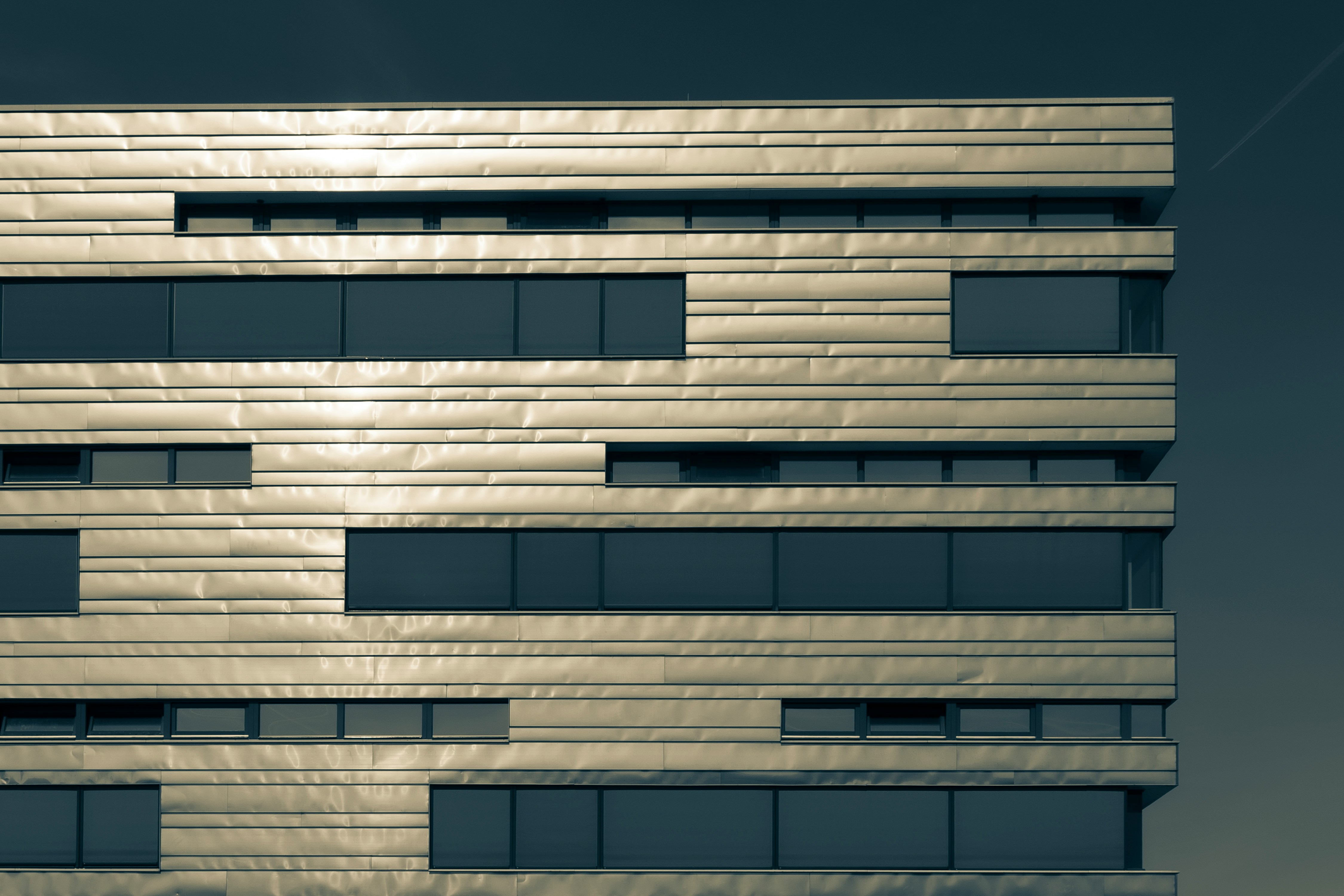 Modern building facade with horizontal metallic panels and windows
