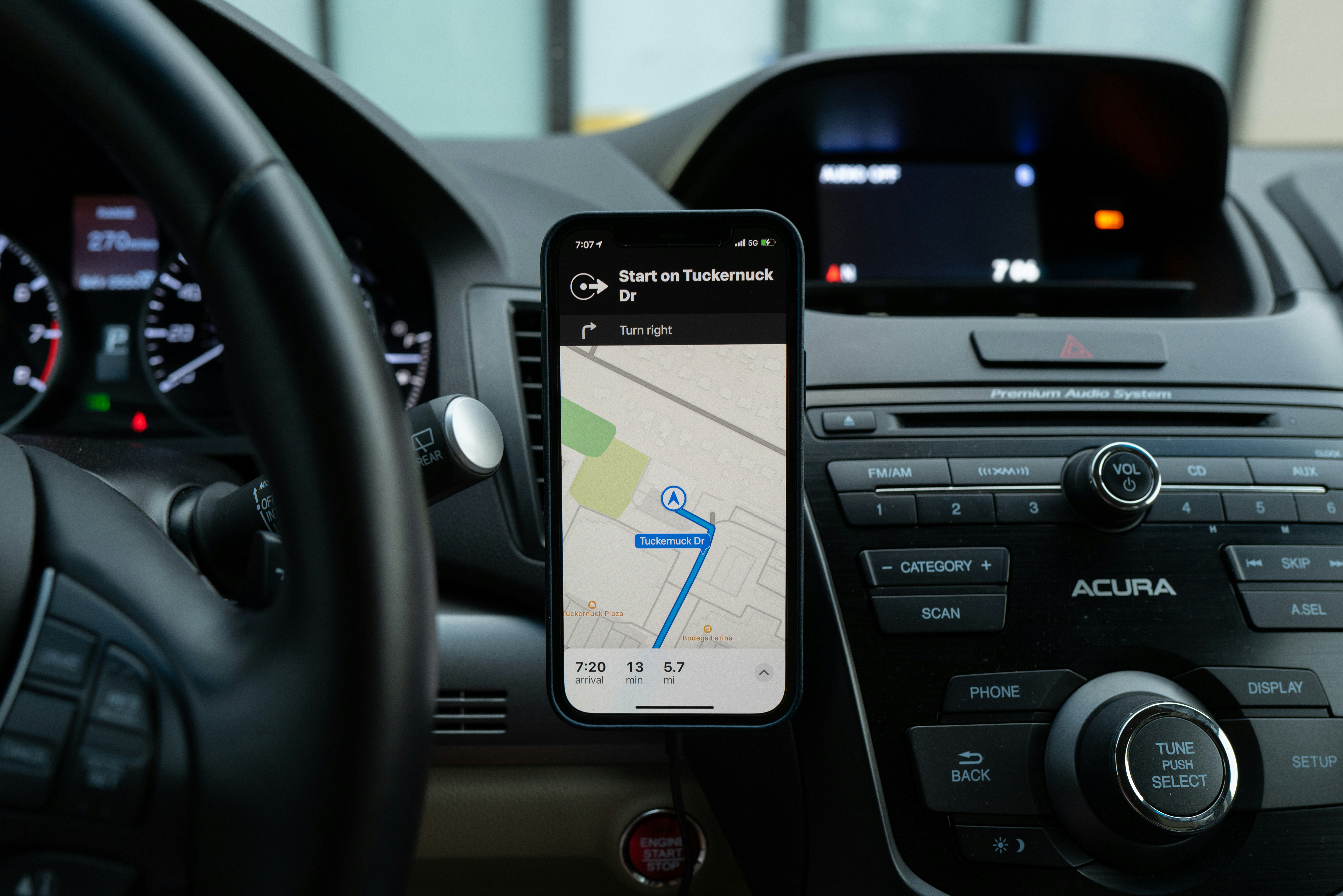 a car dashboard with a mounted cell phone showing a GPS map