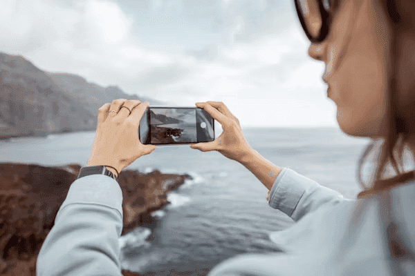 Person framing a photo using a smartphone camera app outdoors