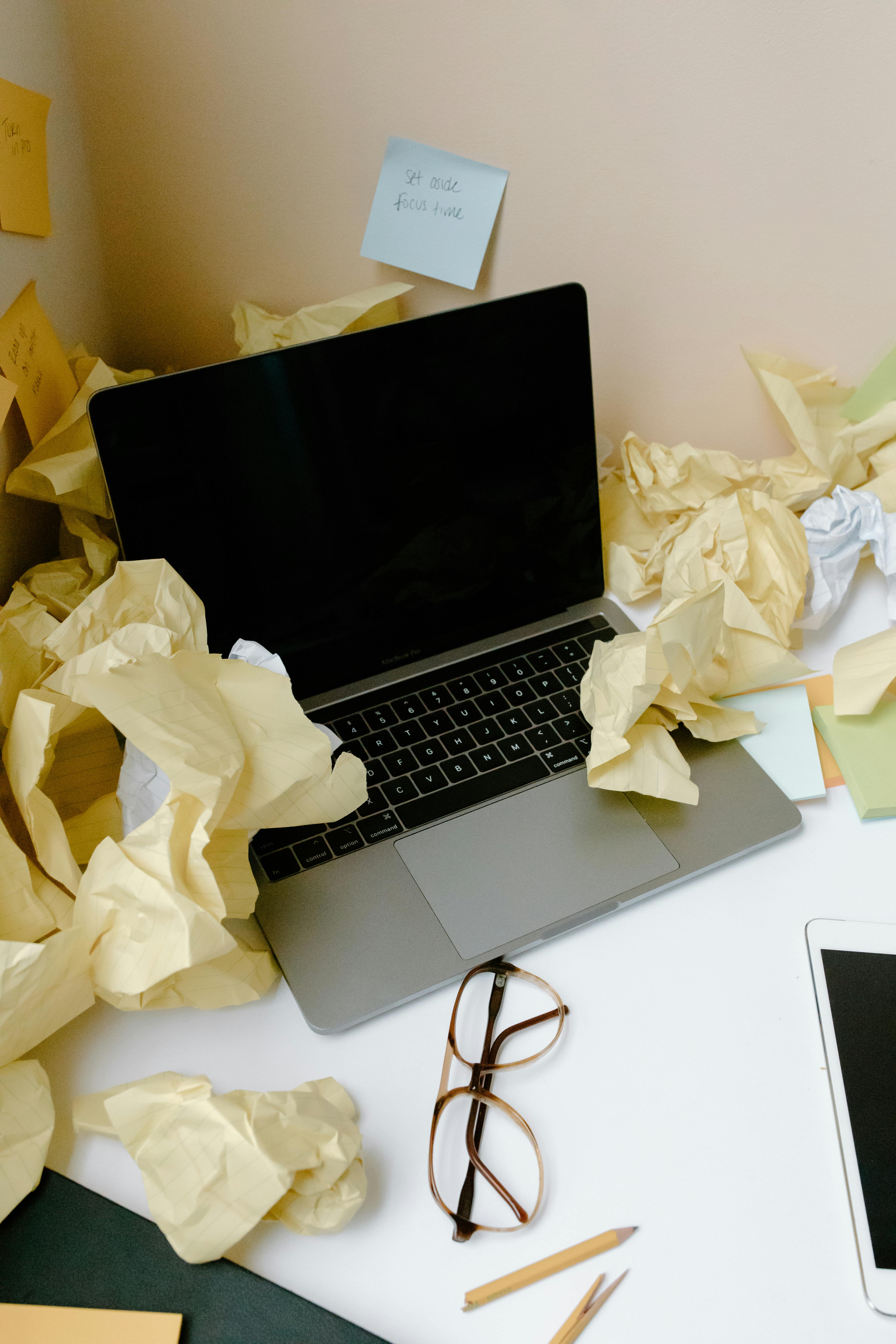 Laptop and Crumpled Papers on a Table