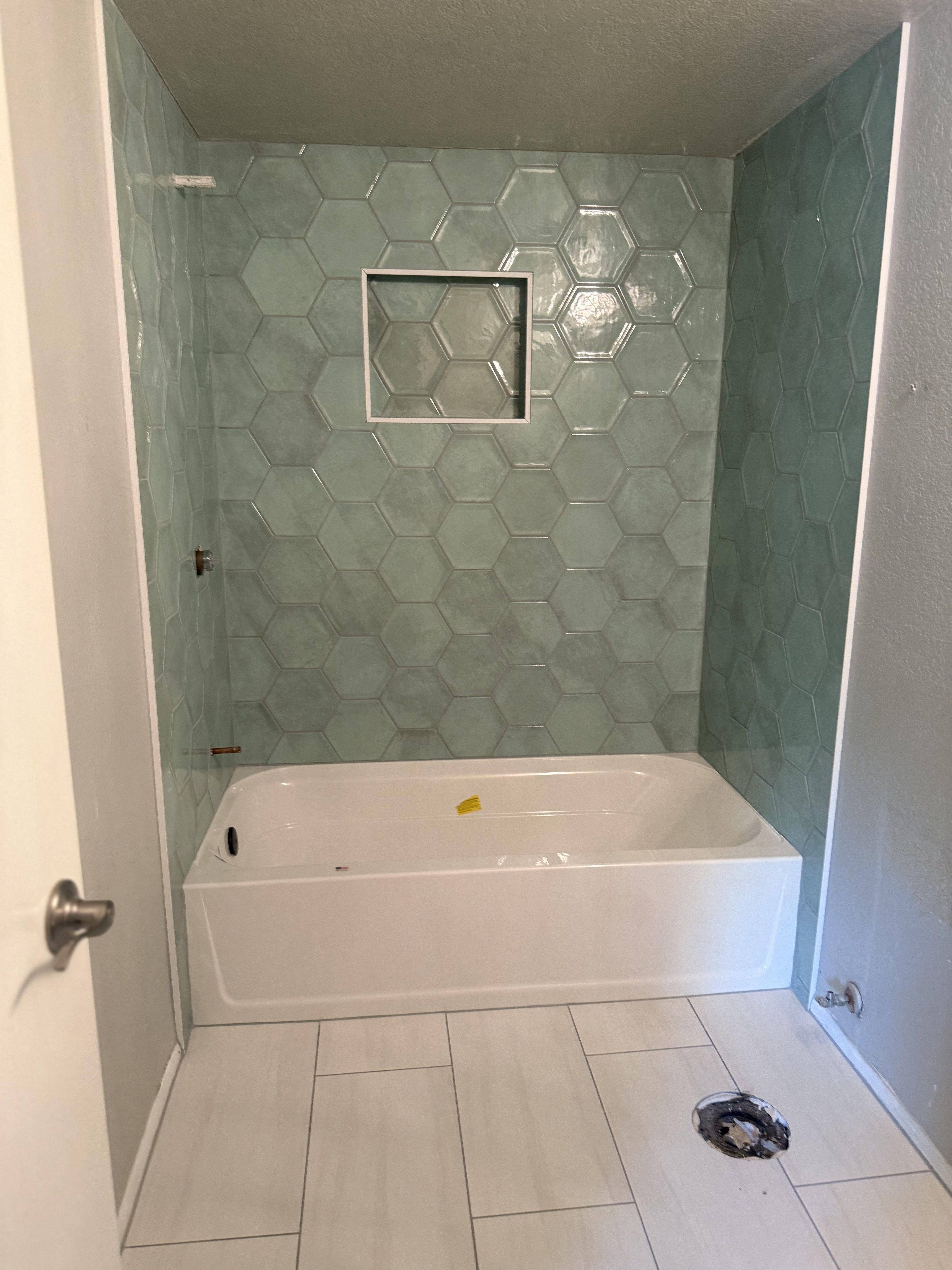 Luxurious bathroom vanity area with a dramatic wall featuring large format natural stone tiles in varying earthy tones and complex veining, serving as a striking backsplash above a double sink vanity.