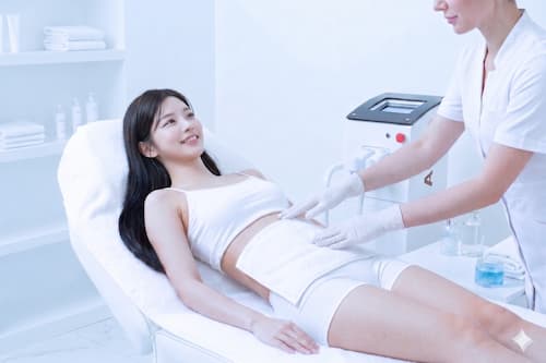 脱毛施術後のお腹に冷たいタオルをあて、優しく肌をクールダウンさせるアフターケア風景