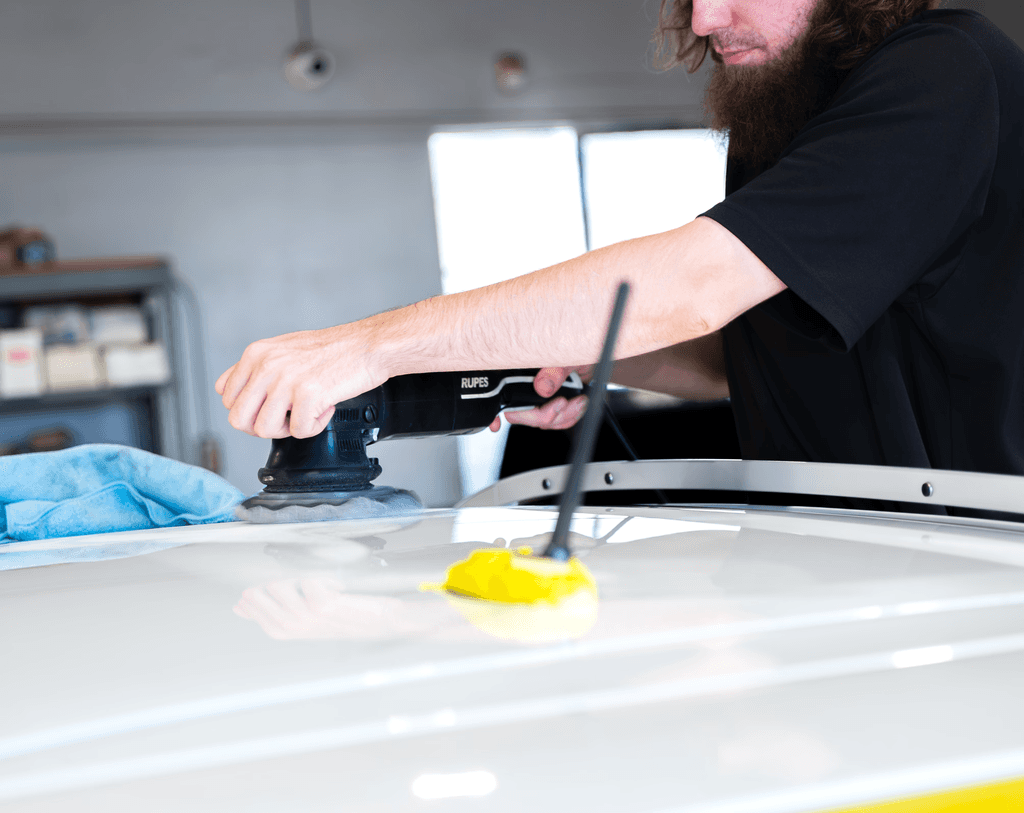 a man detailing the roof of a car