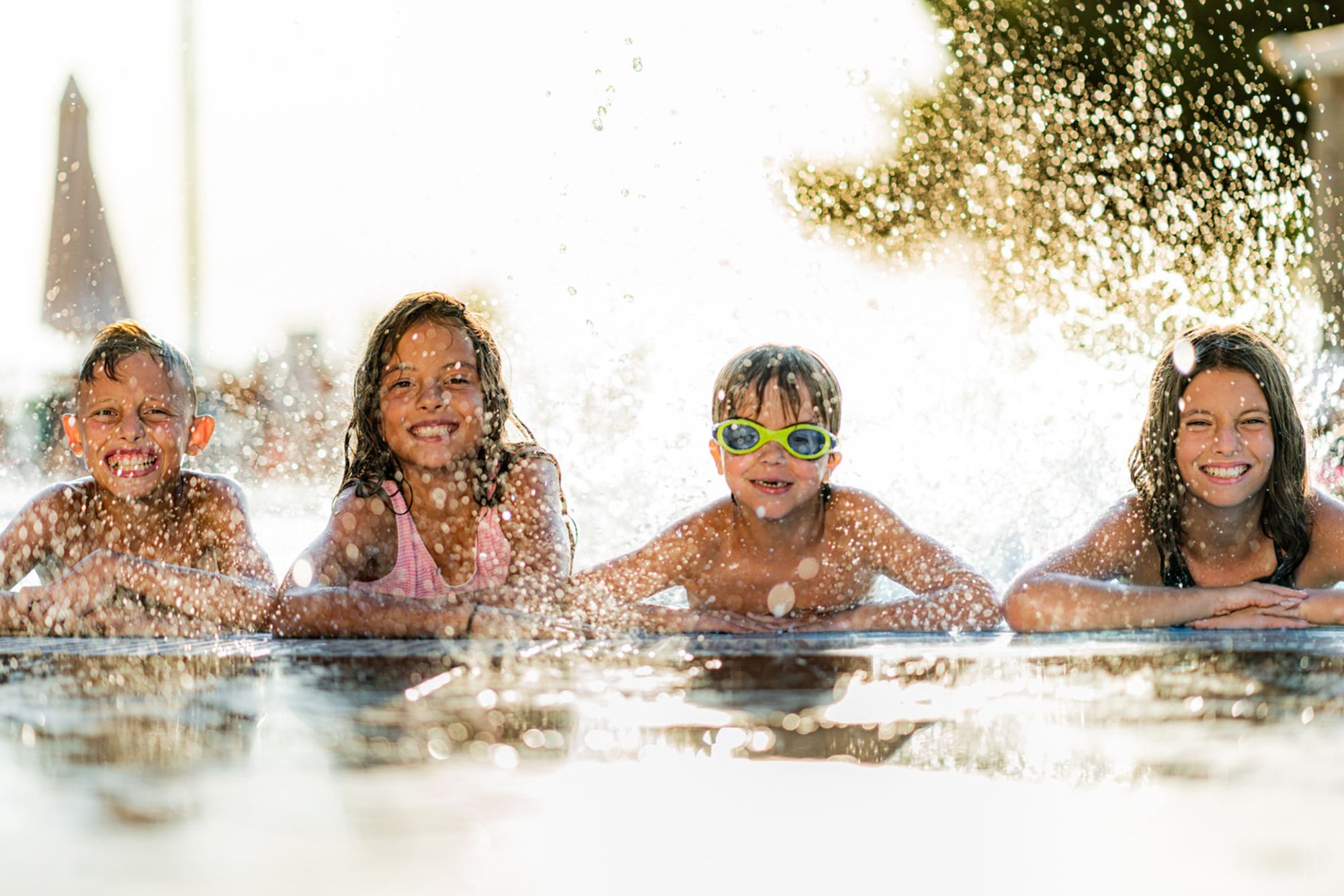 Children enjoying a swimming lesson in a pool, representing a local swim school website designed to increase parent enquiries and bookings