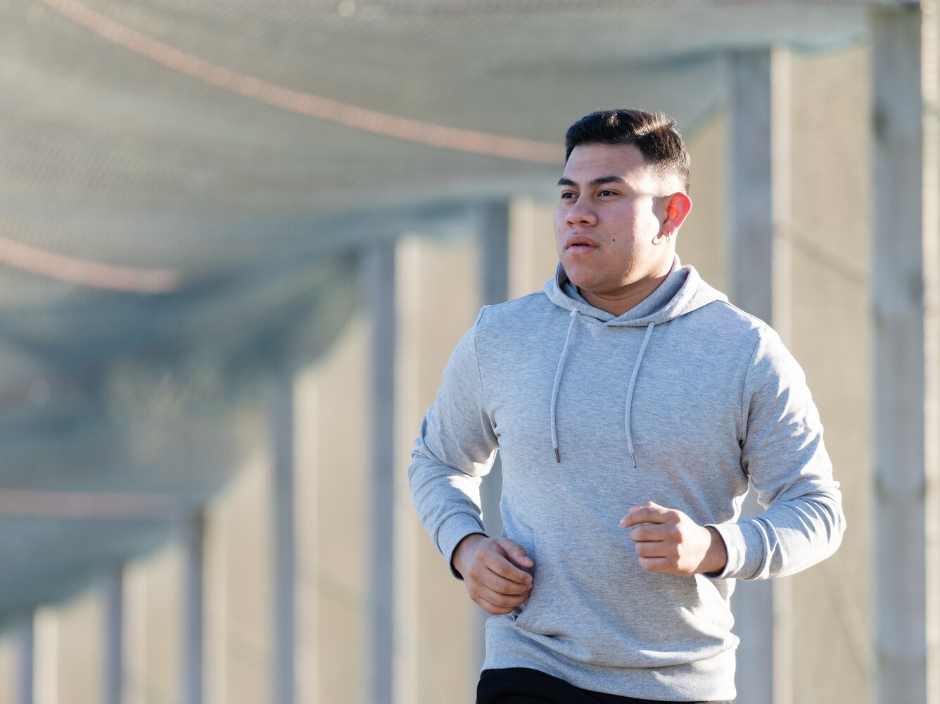 man wearing a grey hoodie on a running weight loss session in his neighborhood