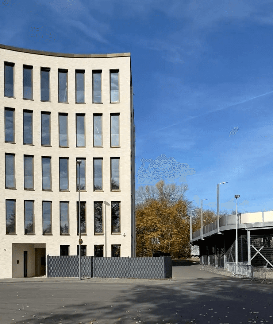 Das Bürogebäude DEUTZ ONE in Köln-Deutz, Sitz der AS Projekte GmbH – modernes Verwaltungsgebäude mit heller Fassade und großflächigen Fenstern unter blauem Himmel.