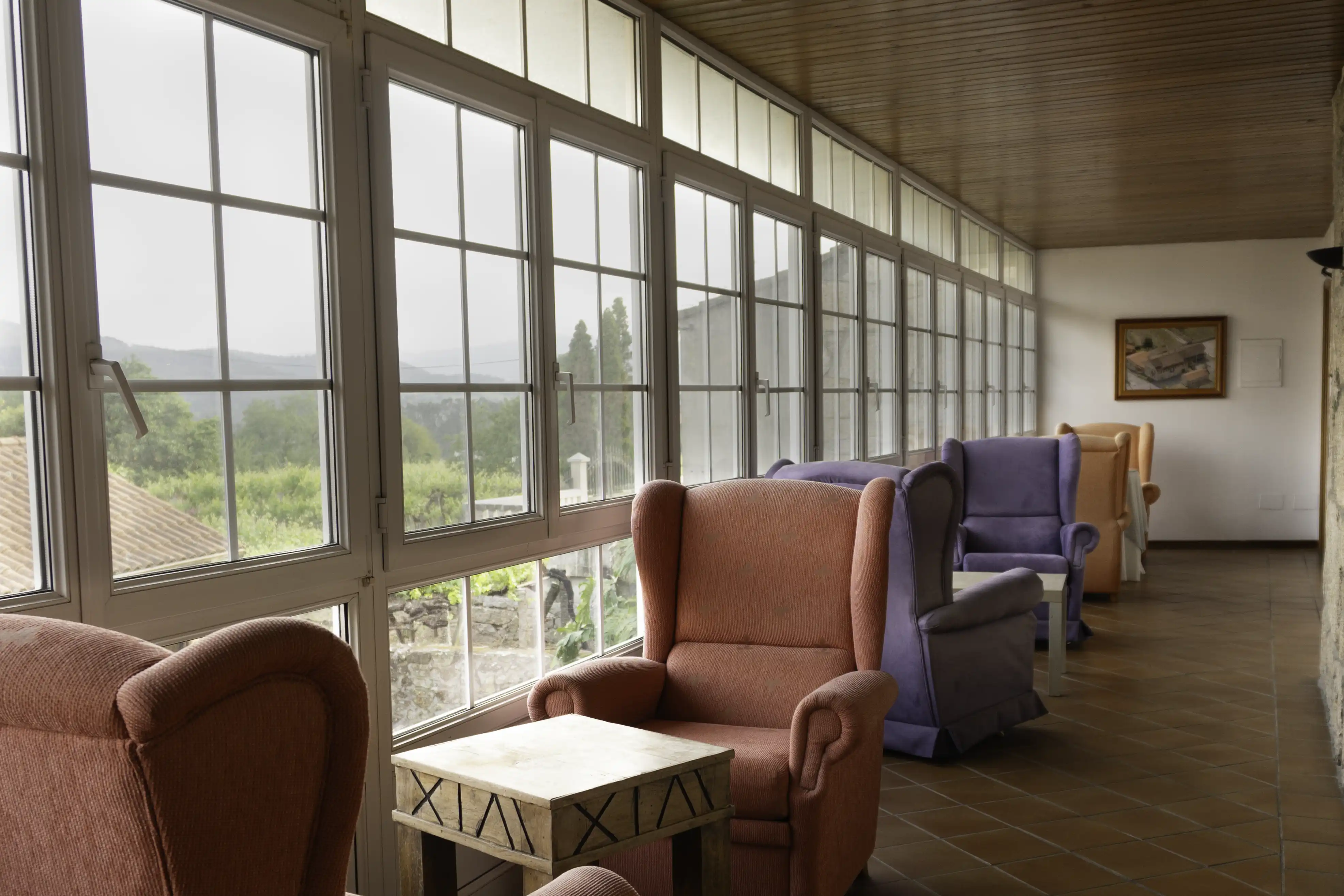 Galería panorámica de Casa Cruceiro con sillones y vistas a los viñedos - Arbo, Galicia