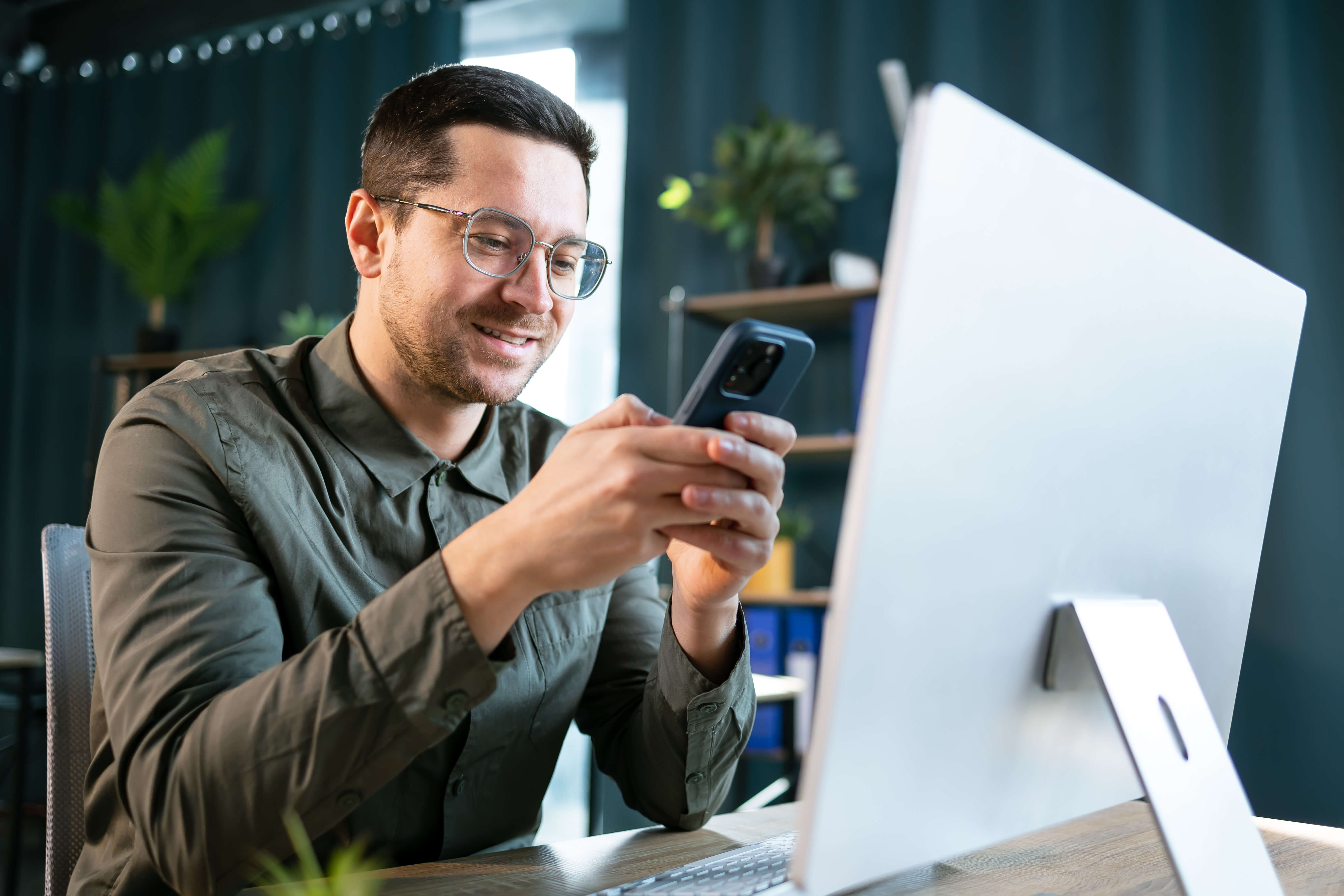 Man on phone and apple computer