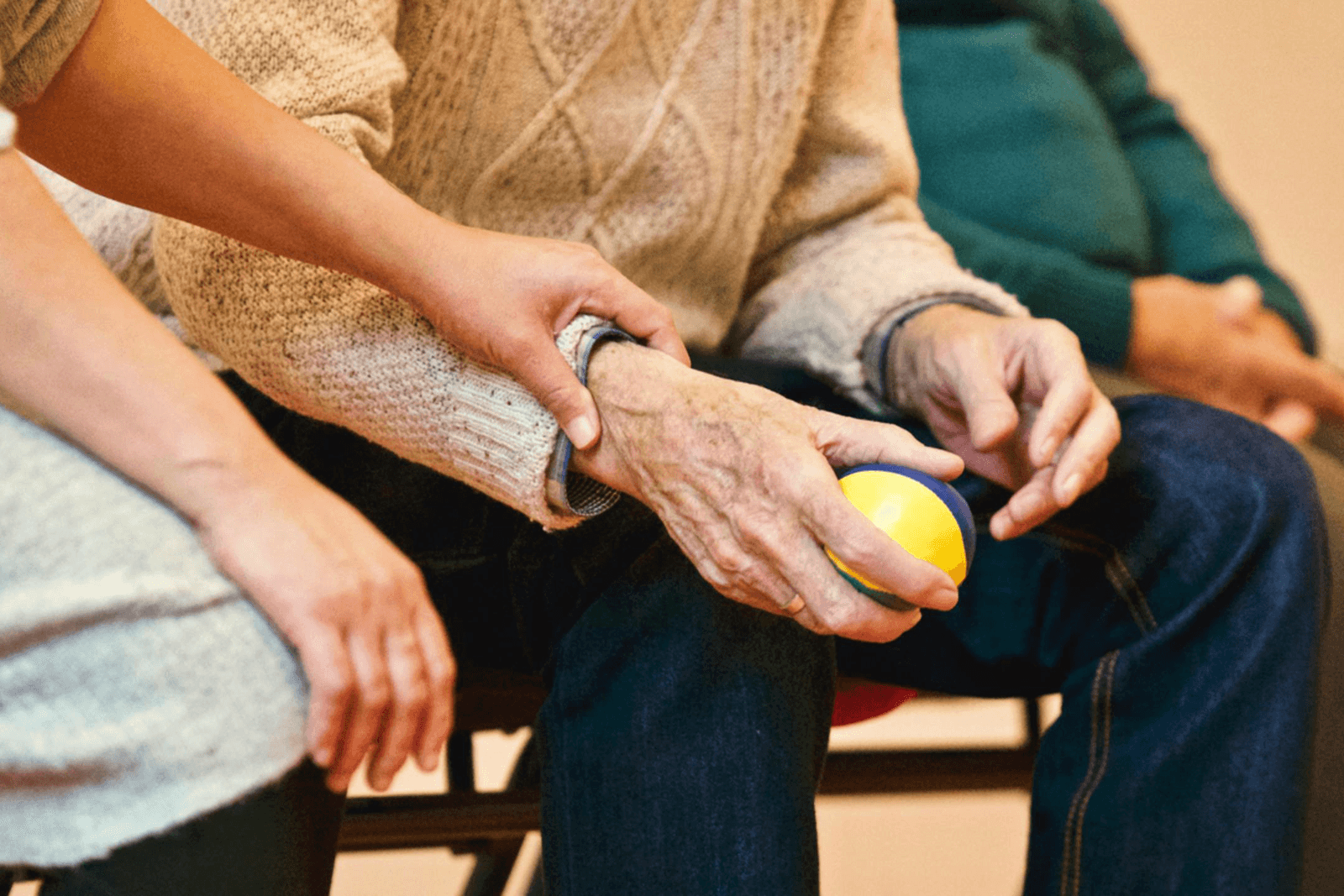 A caregiver gently holding an elderly person's hand