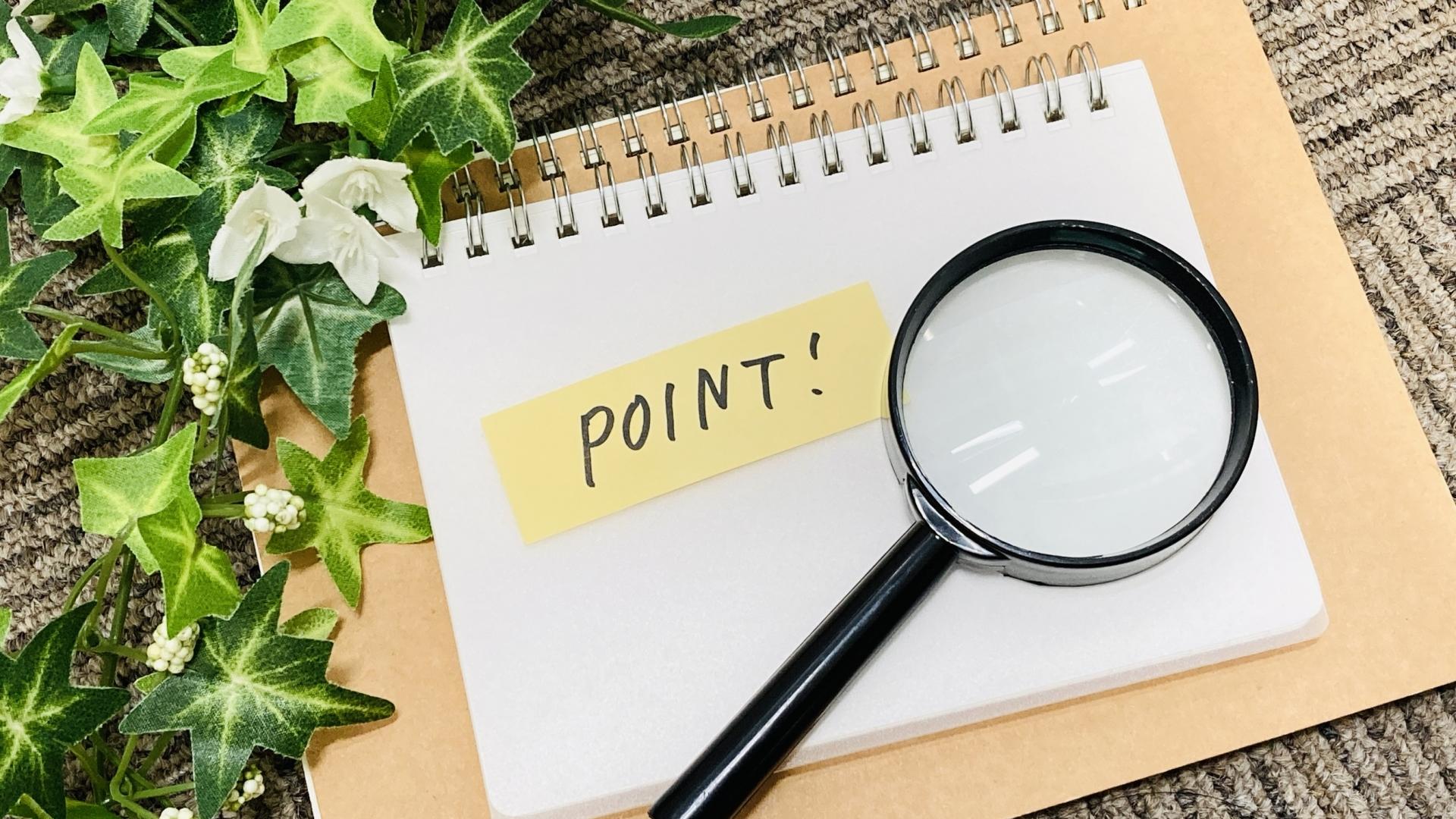 POINT!のメモと虫眼鏡がノートの上に
