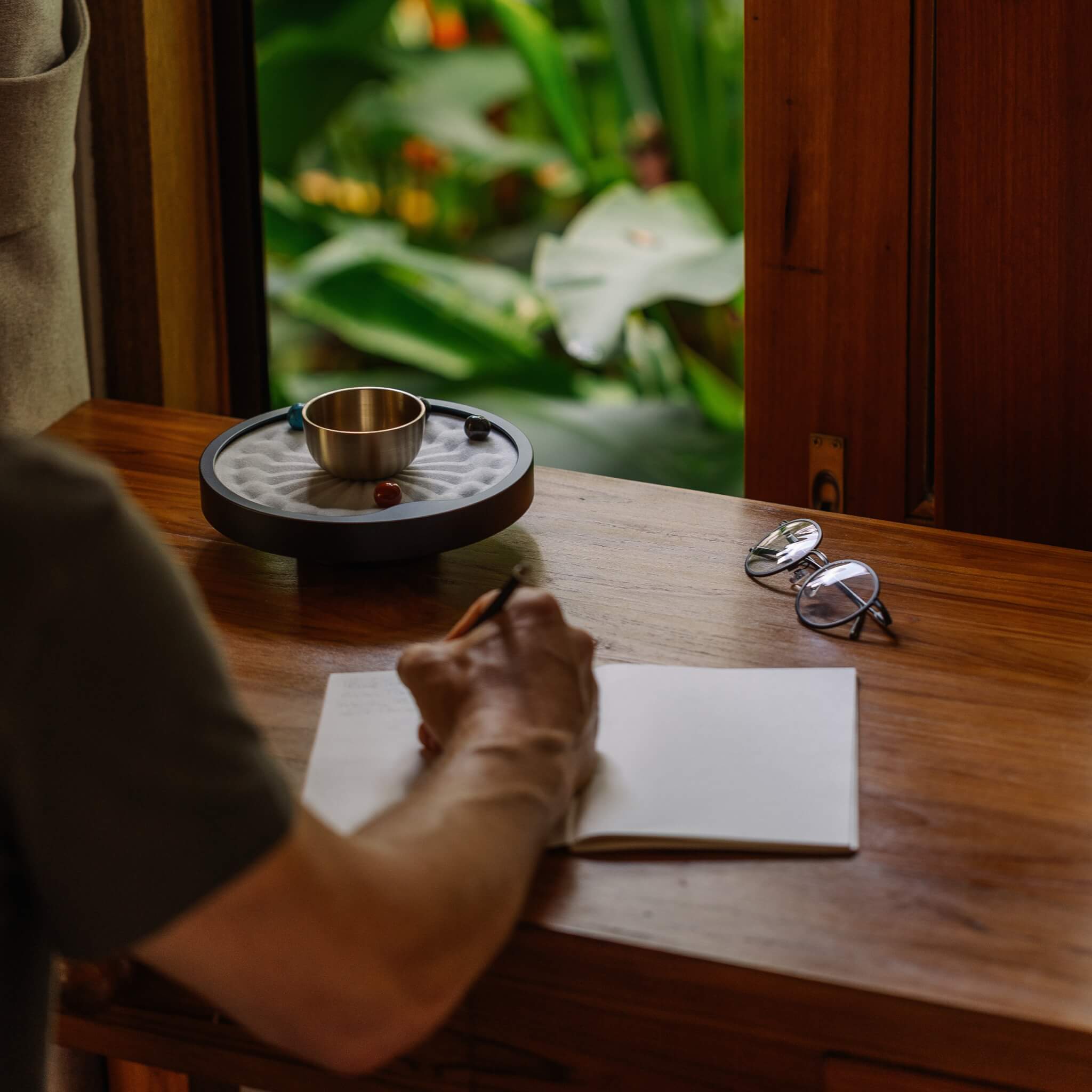 Man journaling with white taoo timer on wooden desk 