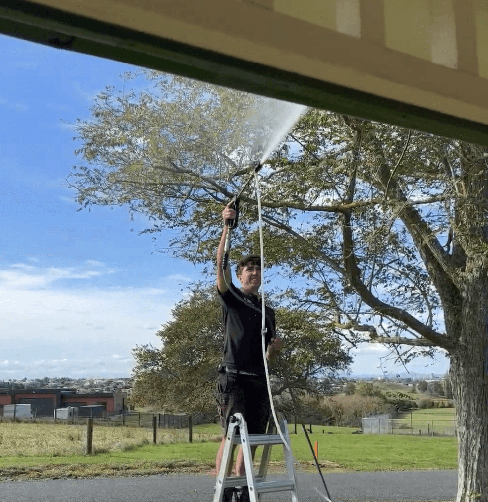 Max clearing debris from gutters on a Hamilton home during a professional gutter clean