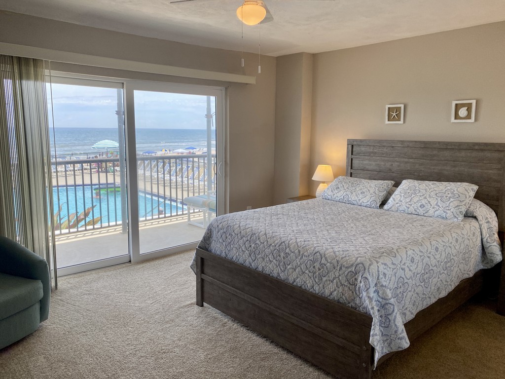 Bedroom with sliding doors overlooking the pool and ocean, Unit 1K at Sandpoint, a vacation rental in Daytona Beach Shores