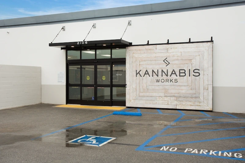 Kannabis Works entrance with sliding barn doors and custom signage on industrial facade.