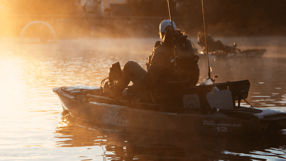 Person som fiskar från en kajak i solnedgången