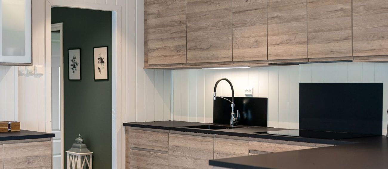 Panel WPC efecto madera en dormitorio y cocina modernos, combinando calidez y resistencia al agua