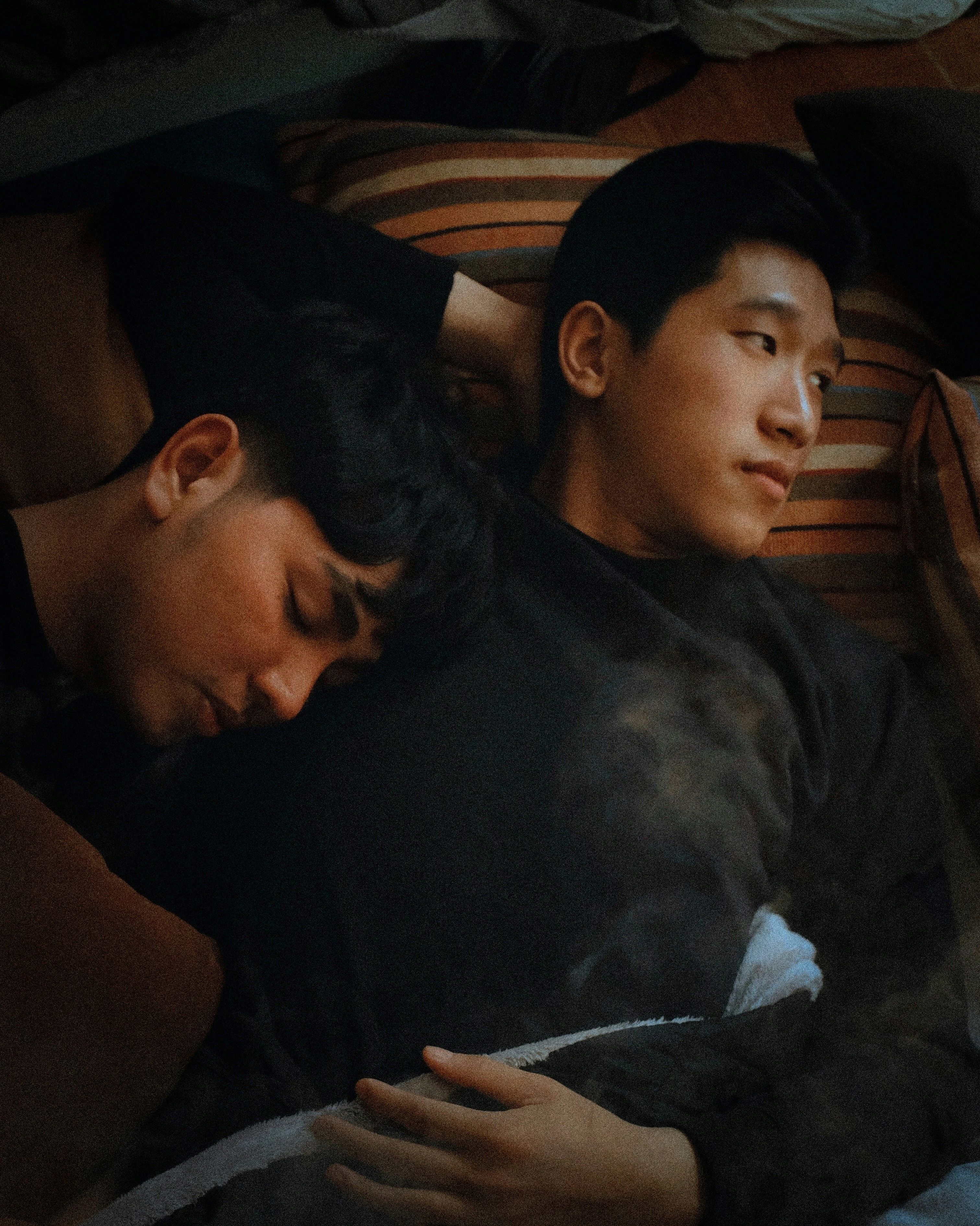 Two people lying close together on a bed, one resting their head on the other’s shoulder, conveying emotional closeness and trust—reflecting how relationship satisfaction is shaped by connection and communication rather than relationship structure.