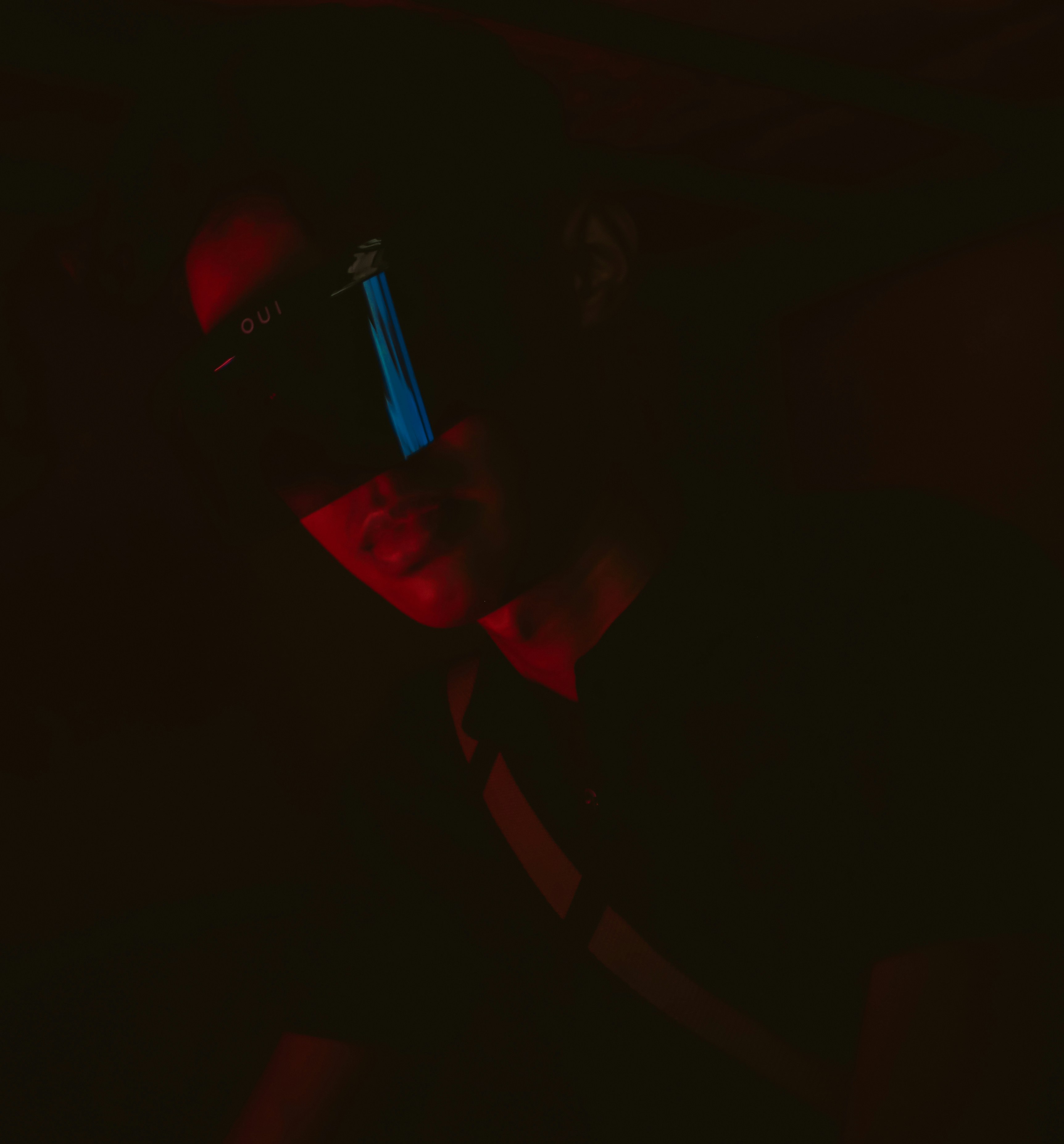 a man in a dark room with a cell phone in his hand