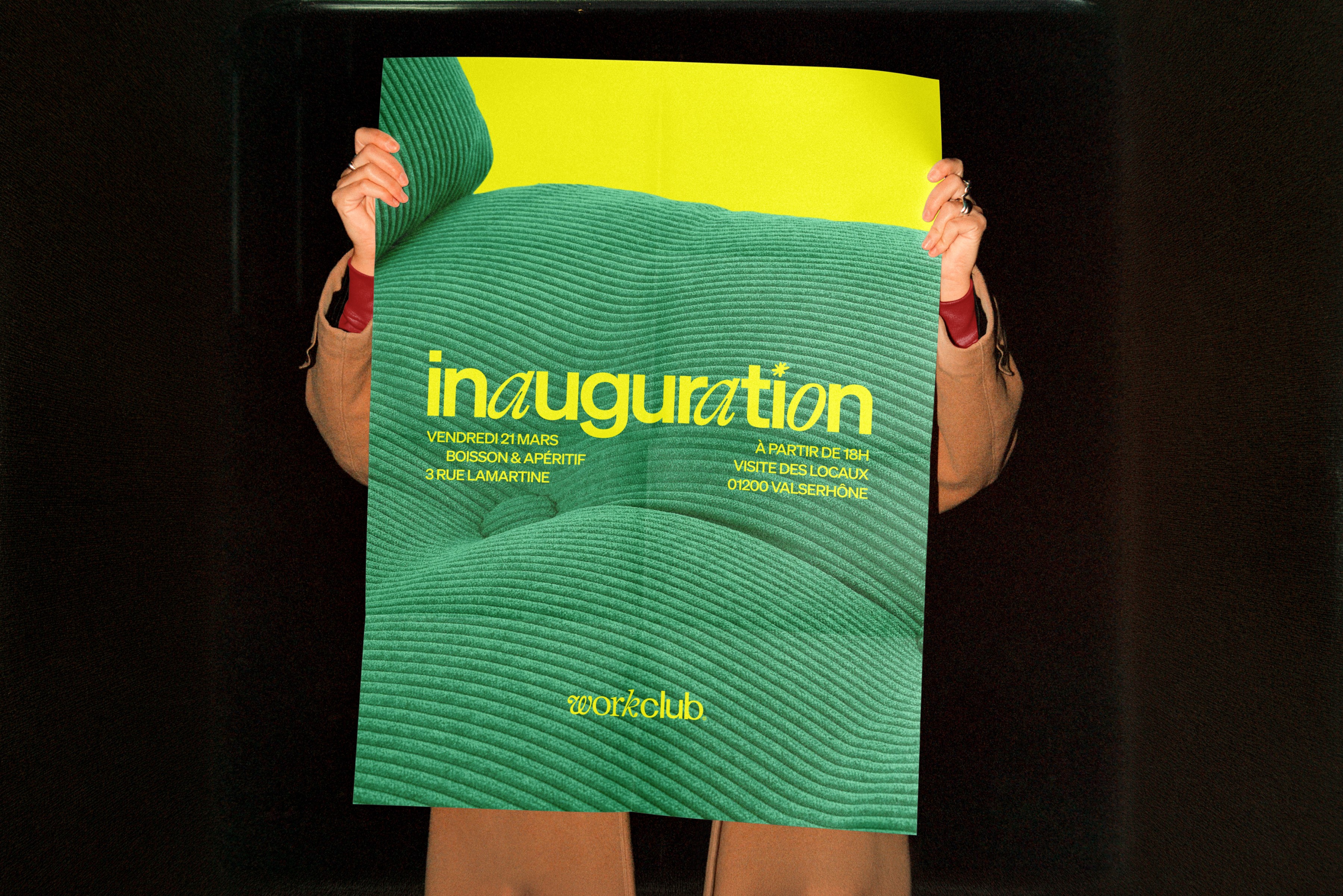 Affiche verte d’inauguration Workclub tenue à bout de bras, grande affiche texturée annonçant l’ouverture de l’espace de coworking à Valserhône.
