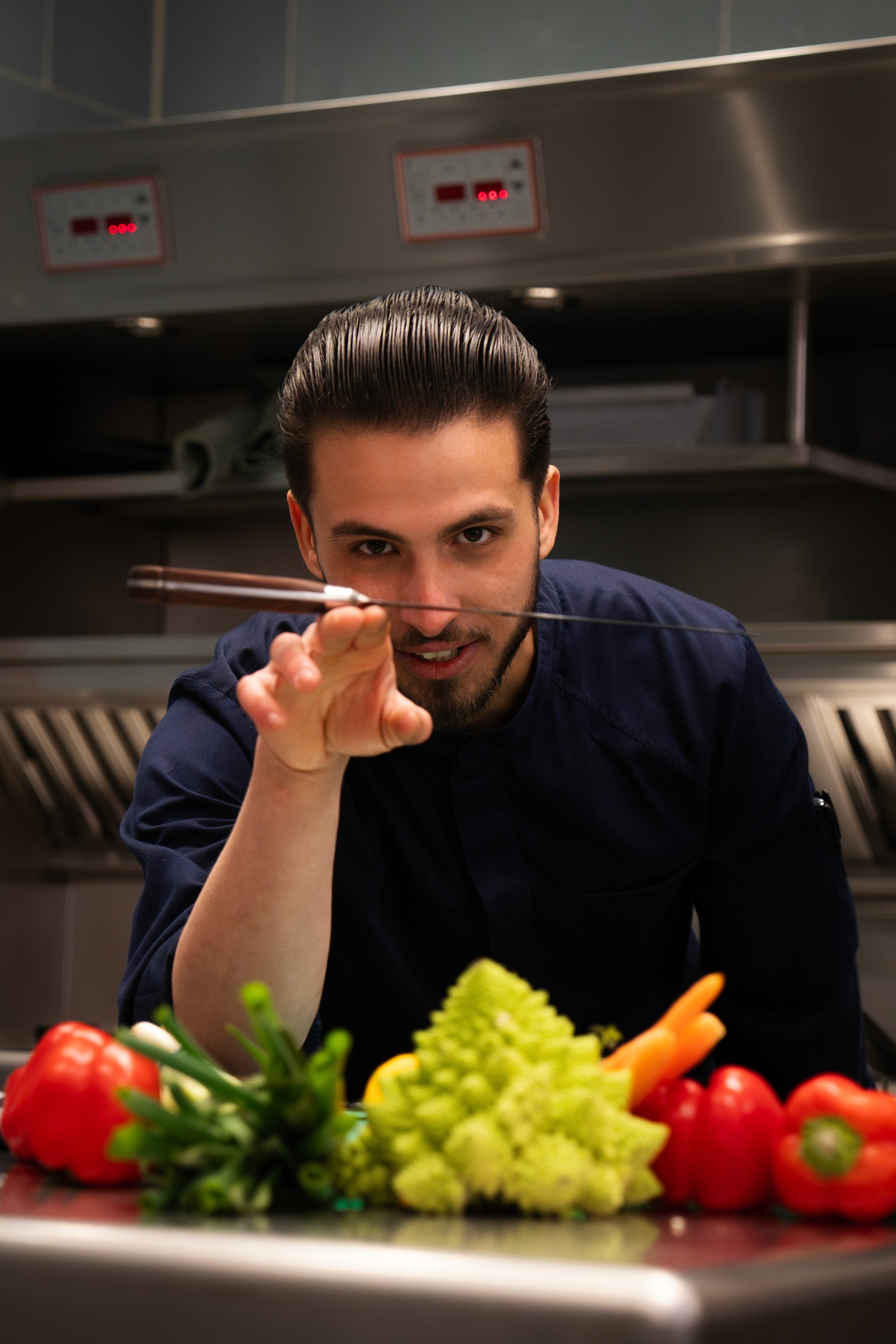 Private chef Noury Yahouni met mes en verse groenten in de keuken