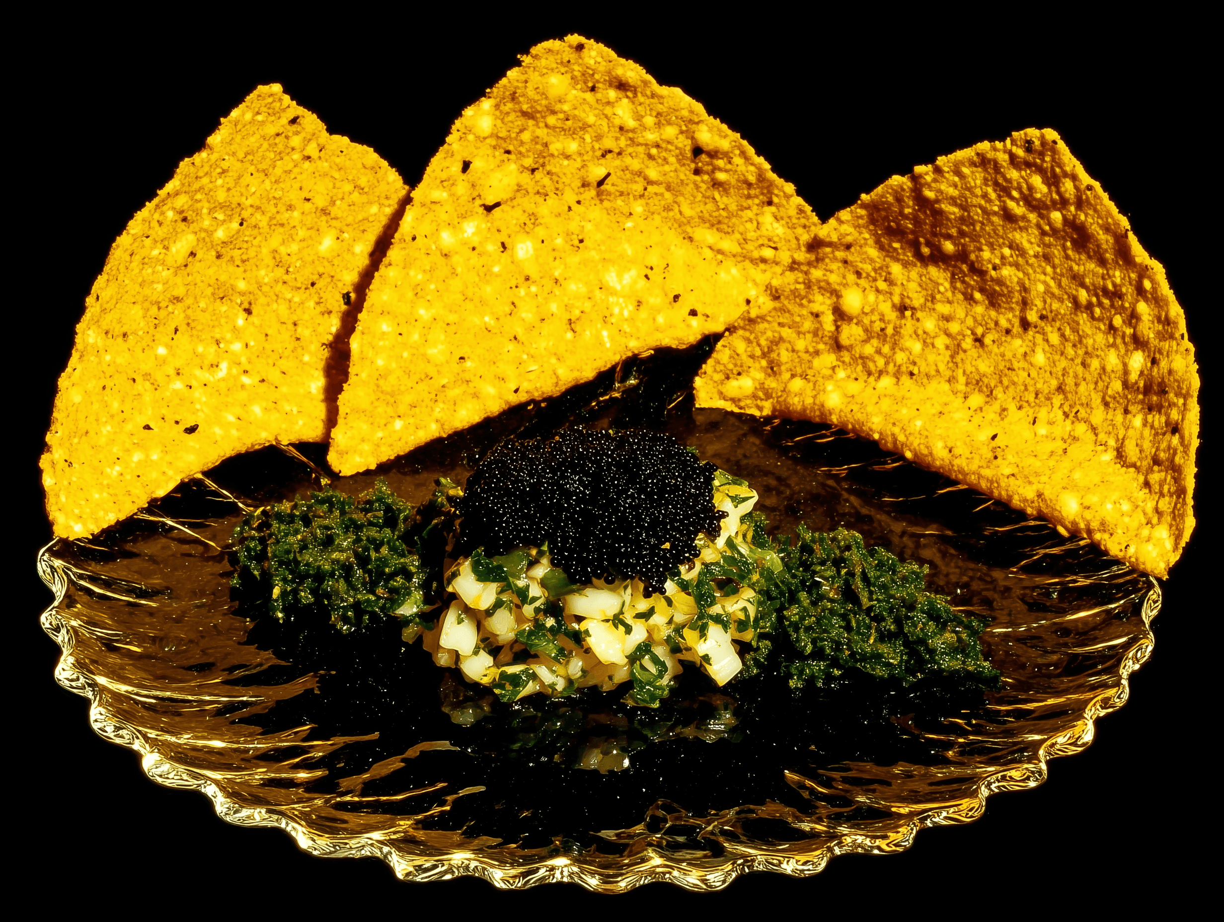Caviar topping a seafood salad, served with tortilla chips on a glass plate.