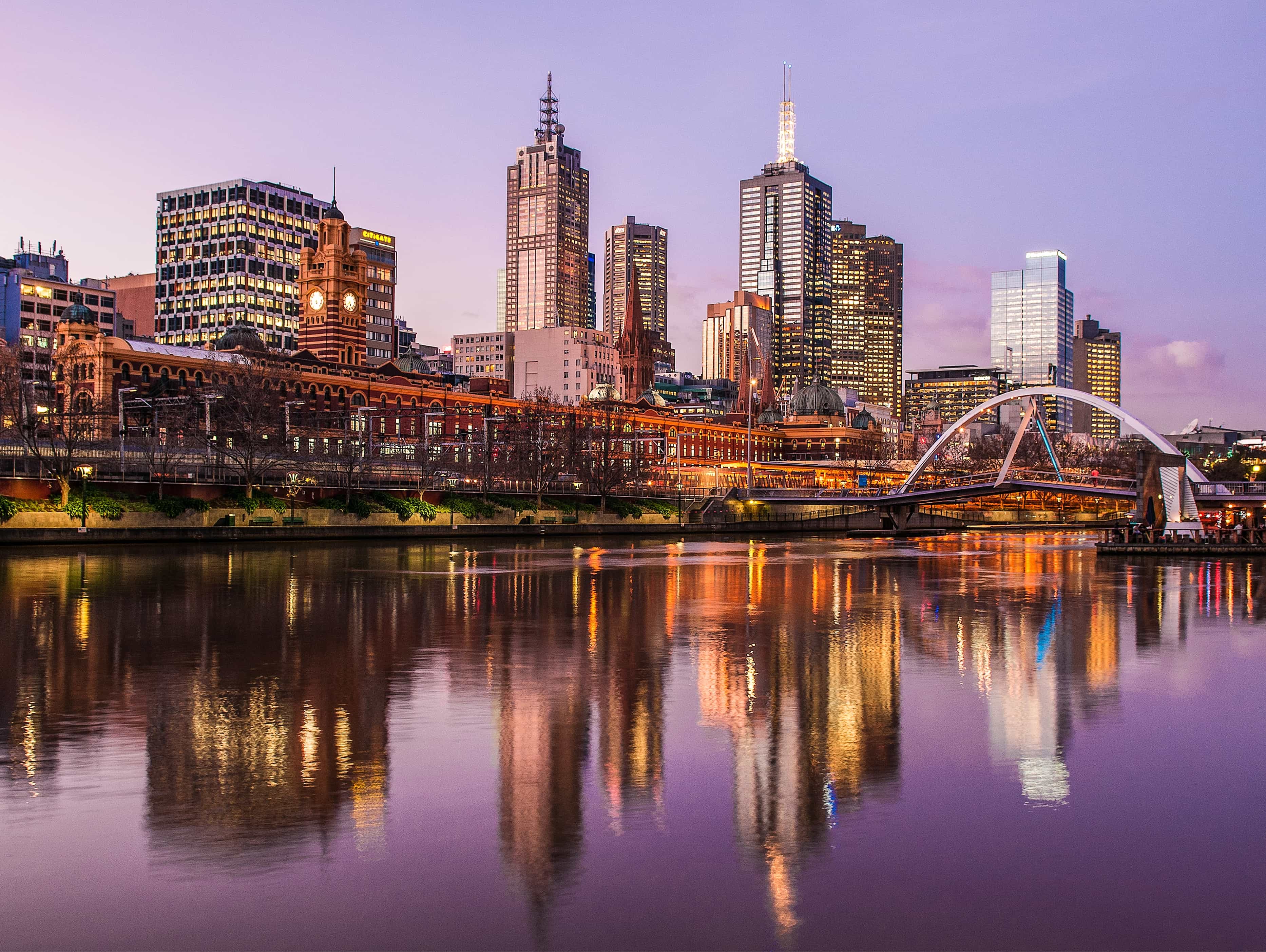a boat traveling down a river next to tall buildings