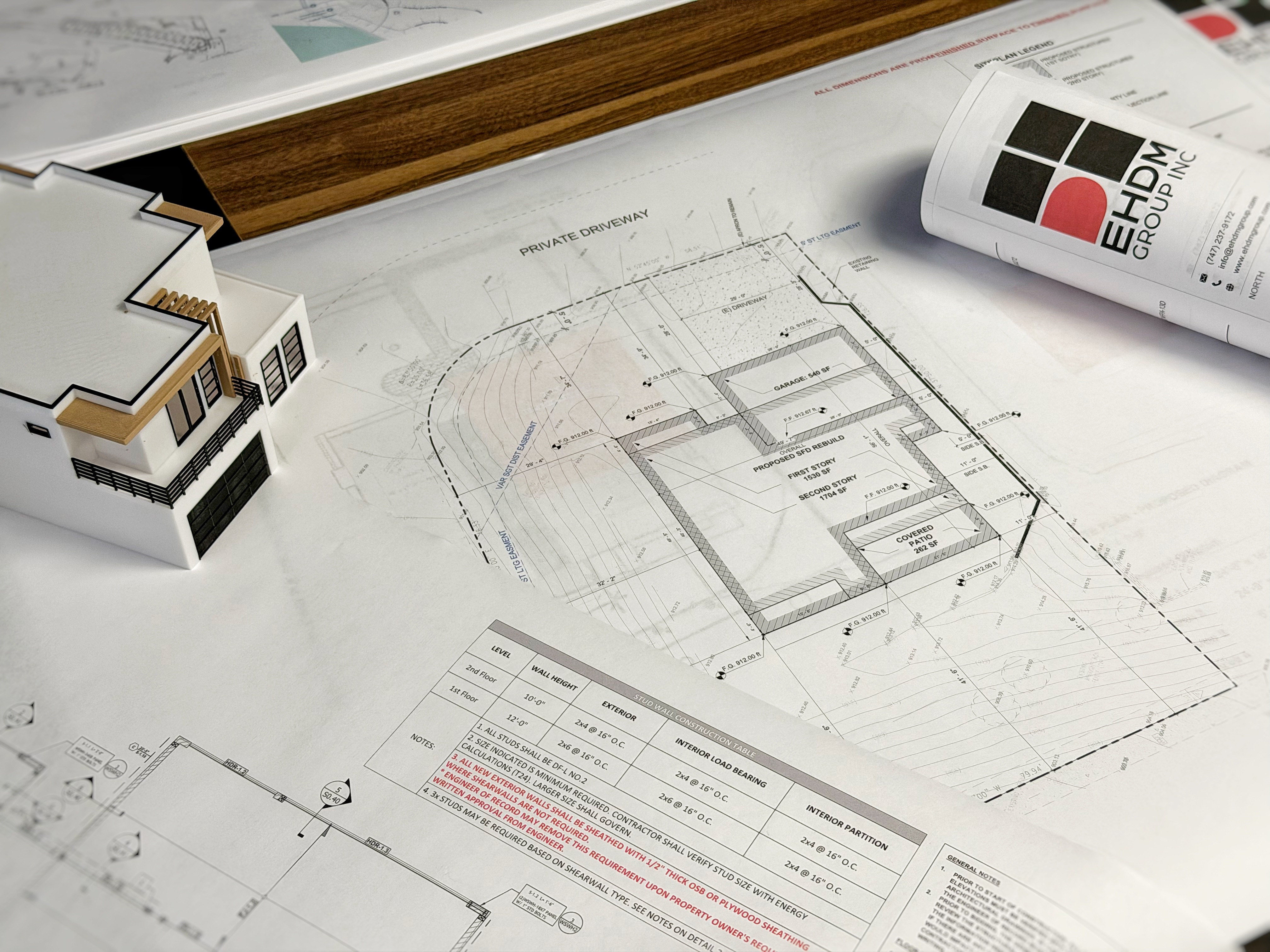 A picture of blueprints stacked on top of each other showing construction documents for a residential project.
