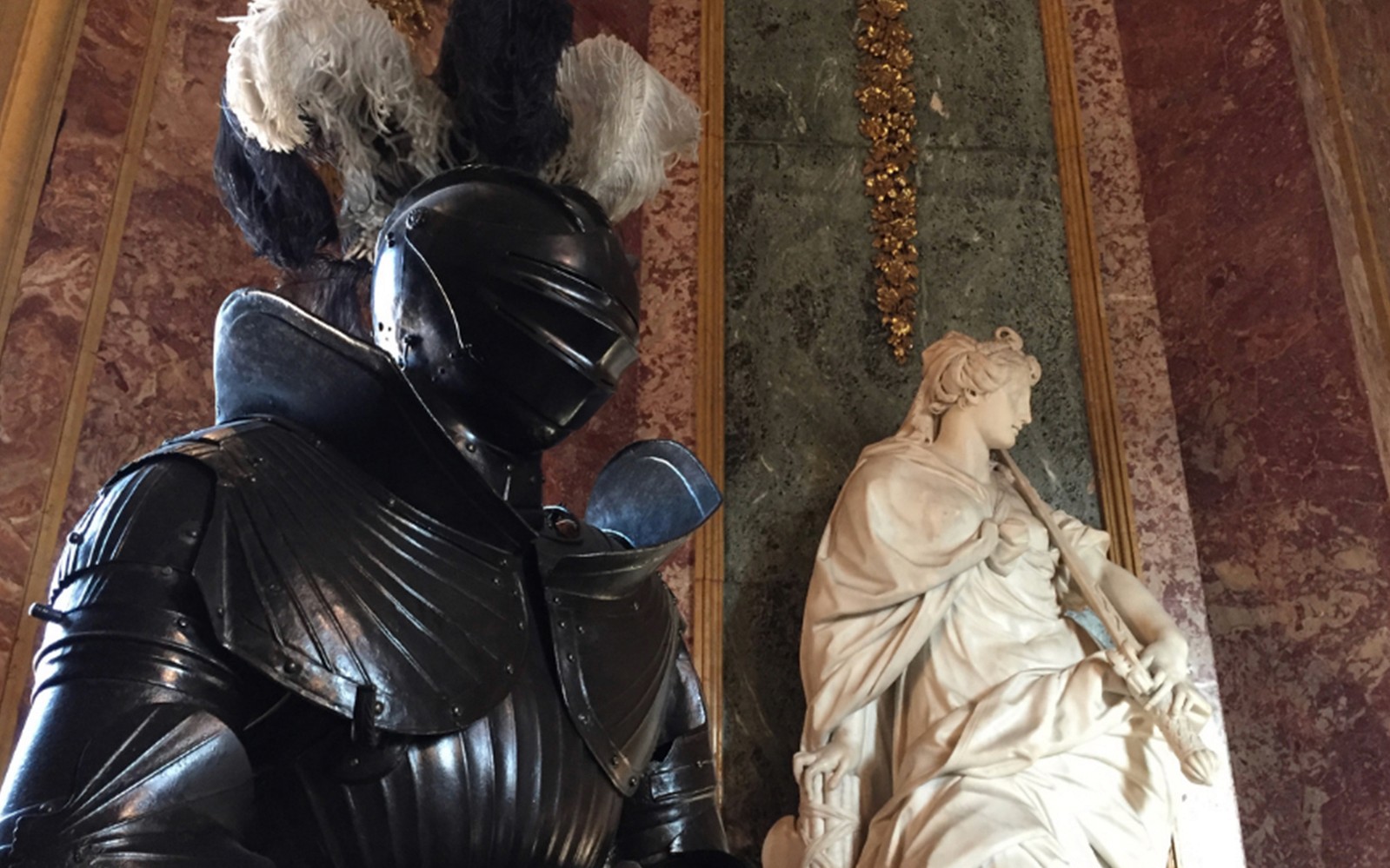 Perisai kesatria dan patung marmar di dalam Istana Diraja Turin.