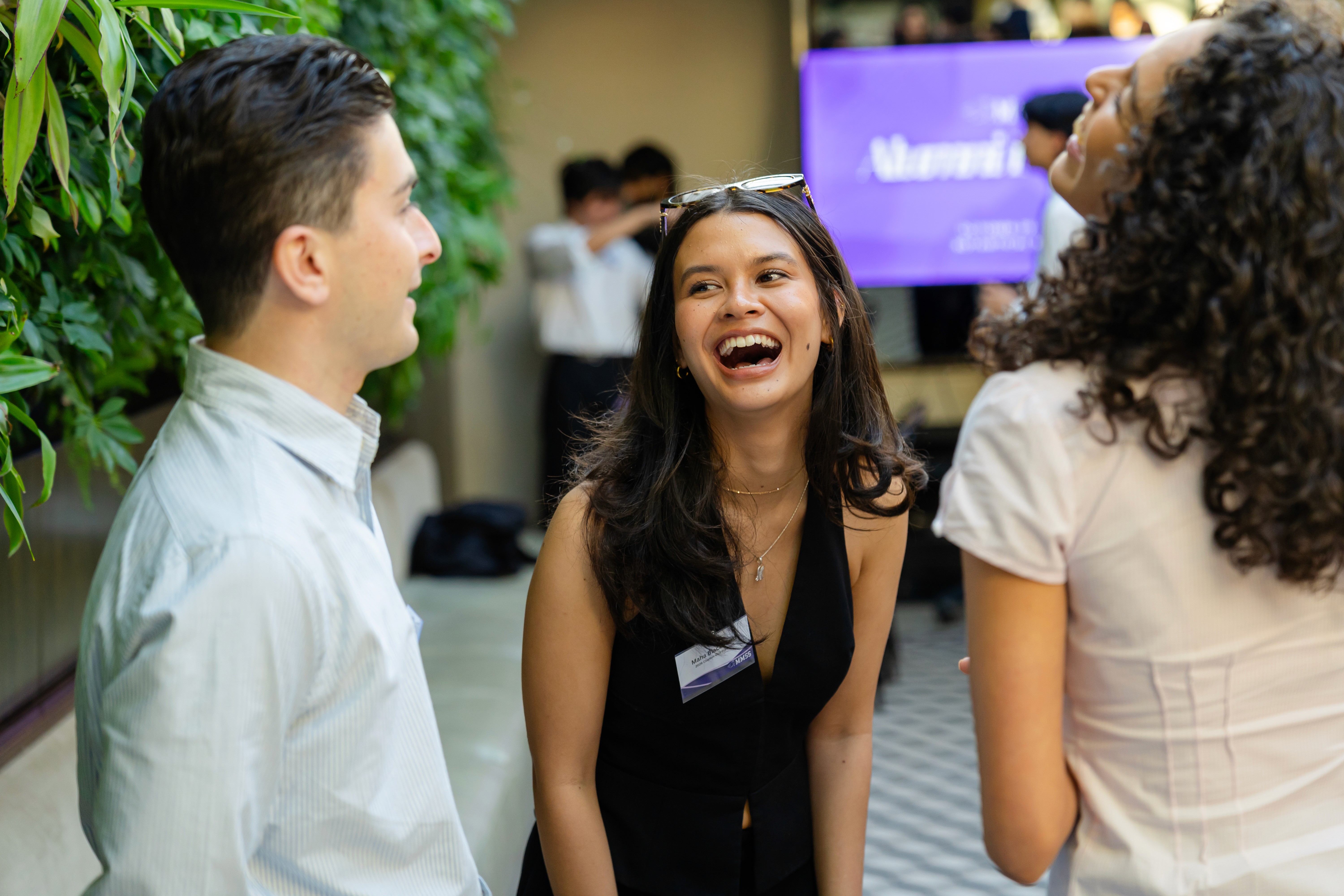 A person with long hair stands against a bright, hazy background, reaching out with one hand.