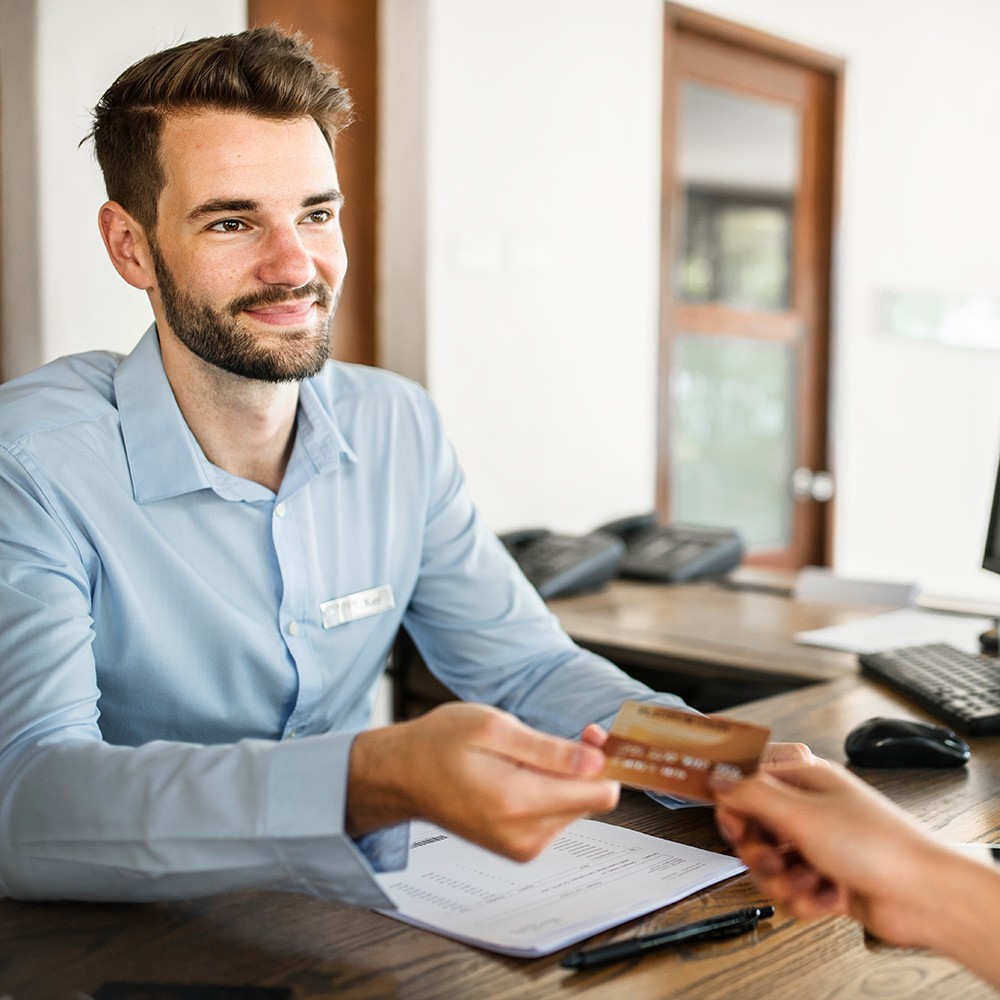 A person handing a credit card to someone