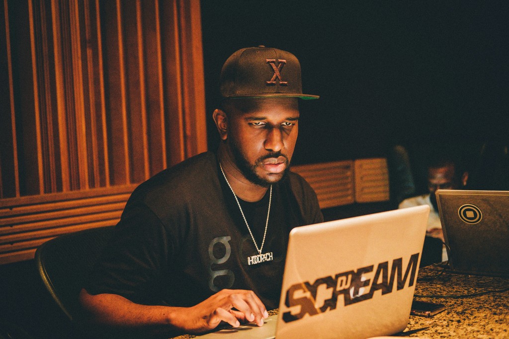 a man in a baseball cap using a laptop