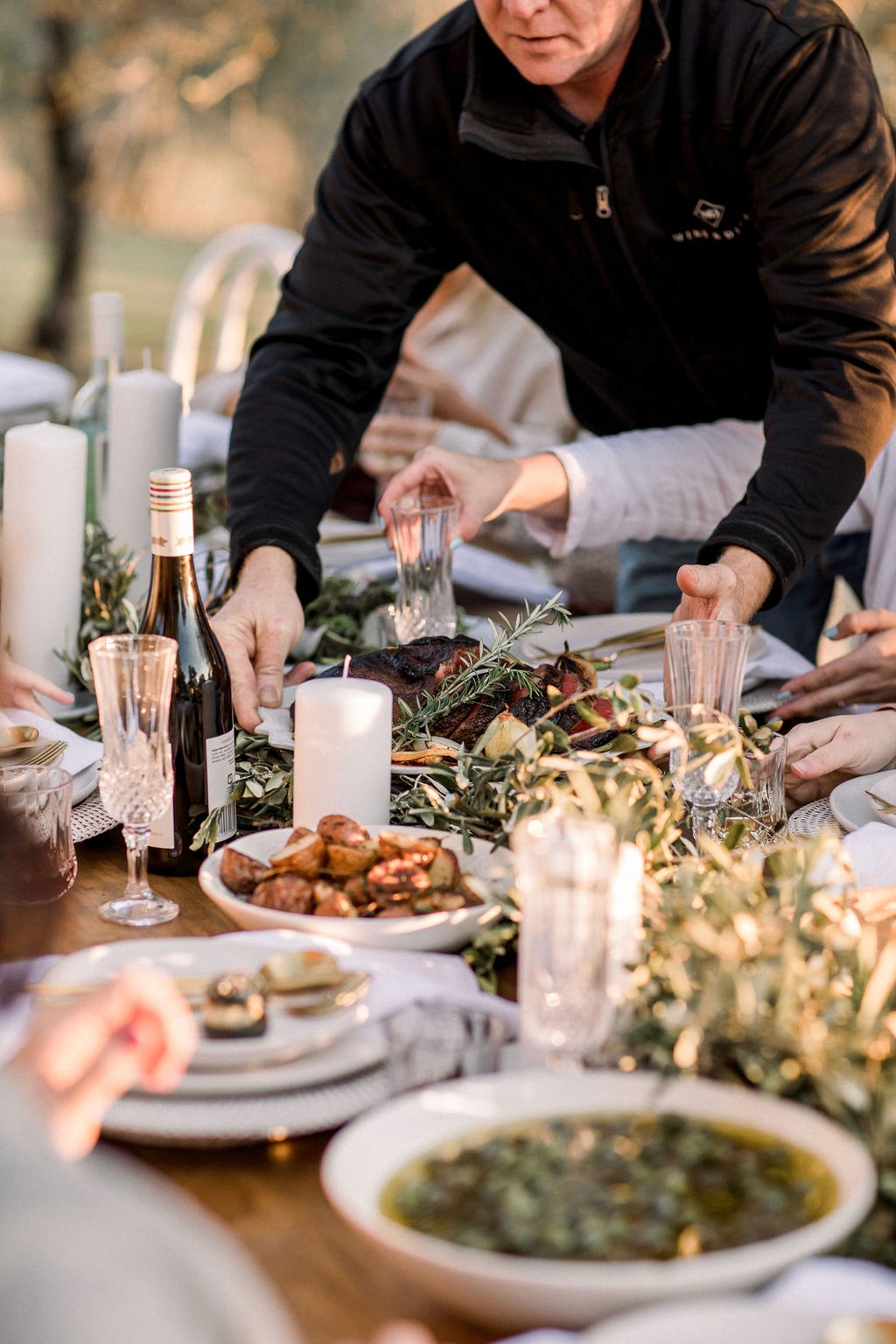 Host putting slow-cooked beef down on the Christmas Lunch table to share with guests