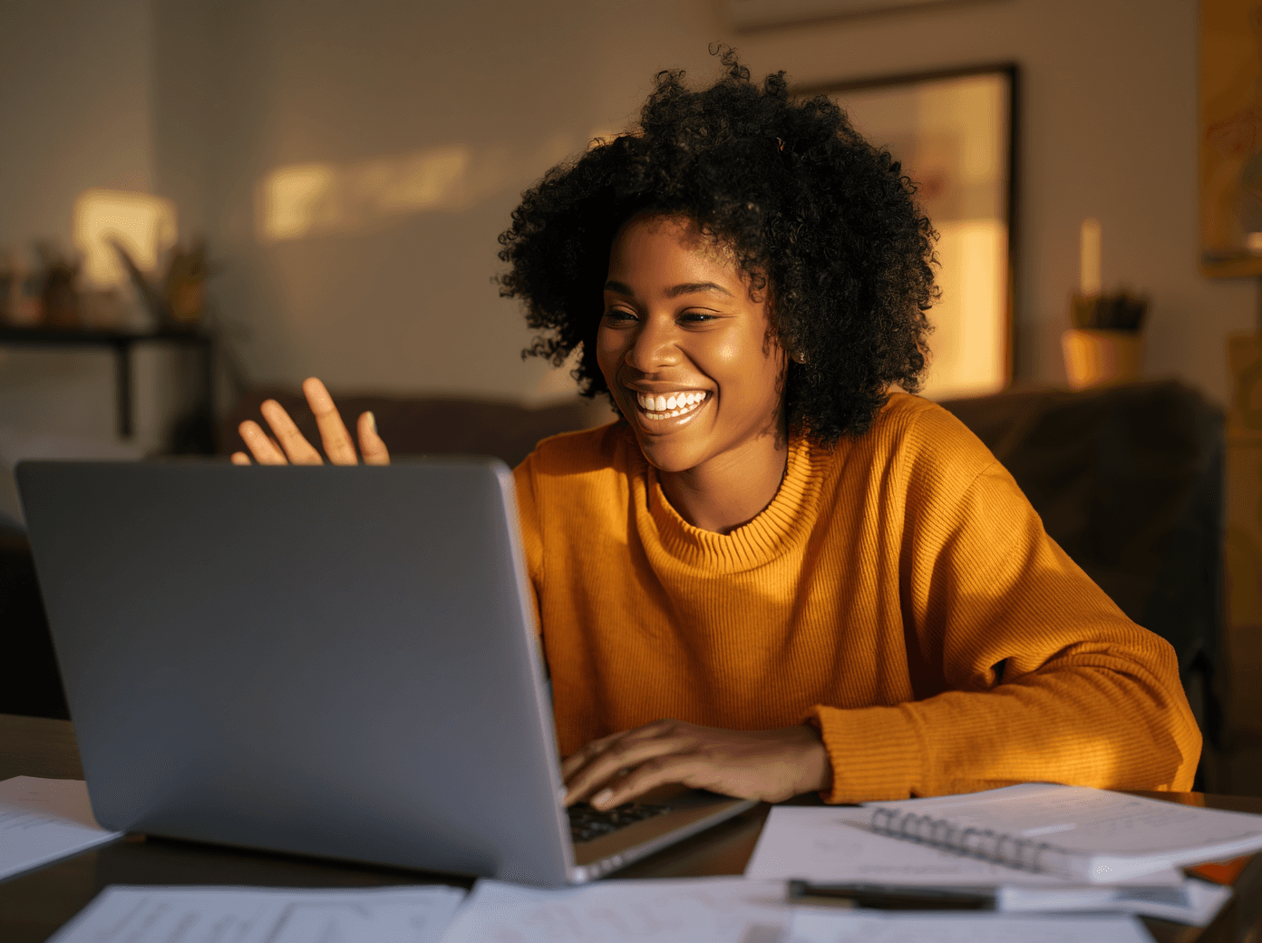 A group of people gather outside a rustic stone building surrounded by lush greenery and flowering plants, bathed in warm, natural sunlight, capturing a serene and welcoming ambiance.
