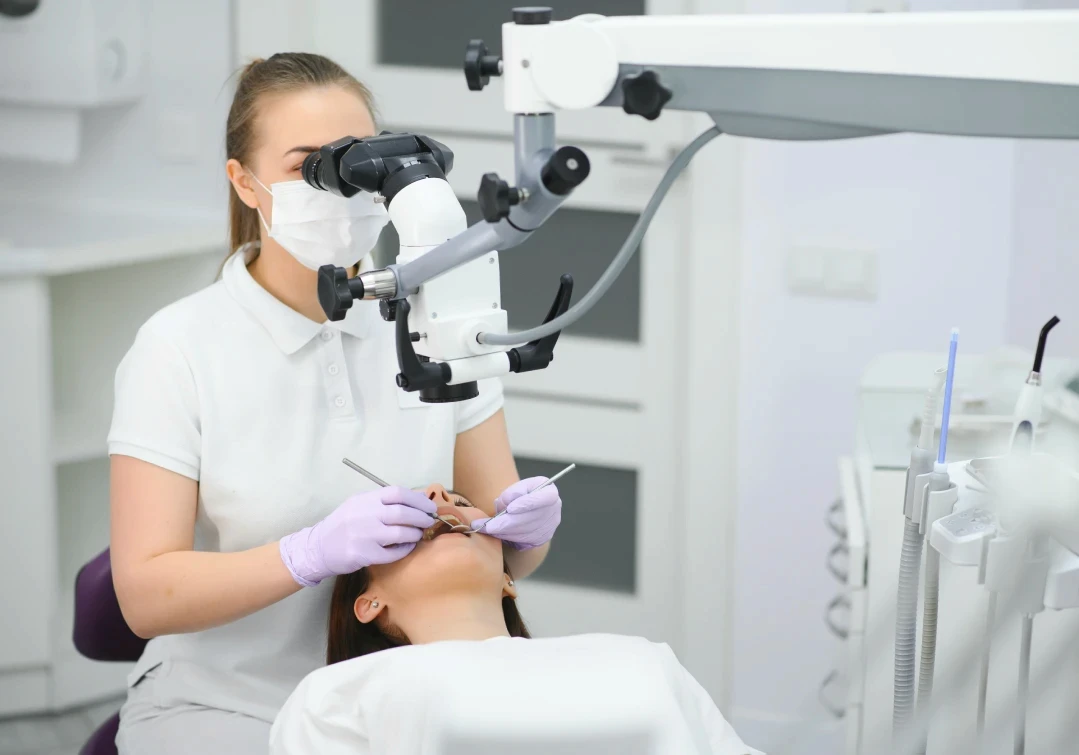 Kobieta z uśmiechem prezentująca efekty bondingu na swoich zębach.