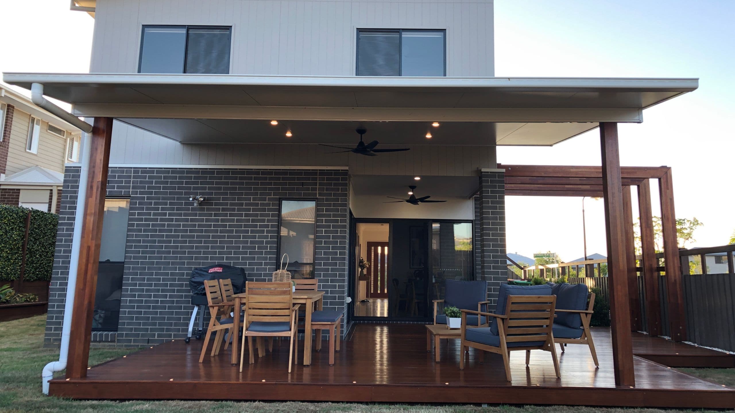 Covered outdoor living area with wooden deck and modern furniture in a Brisbane home