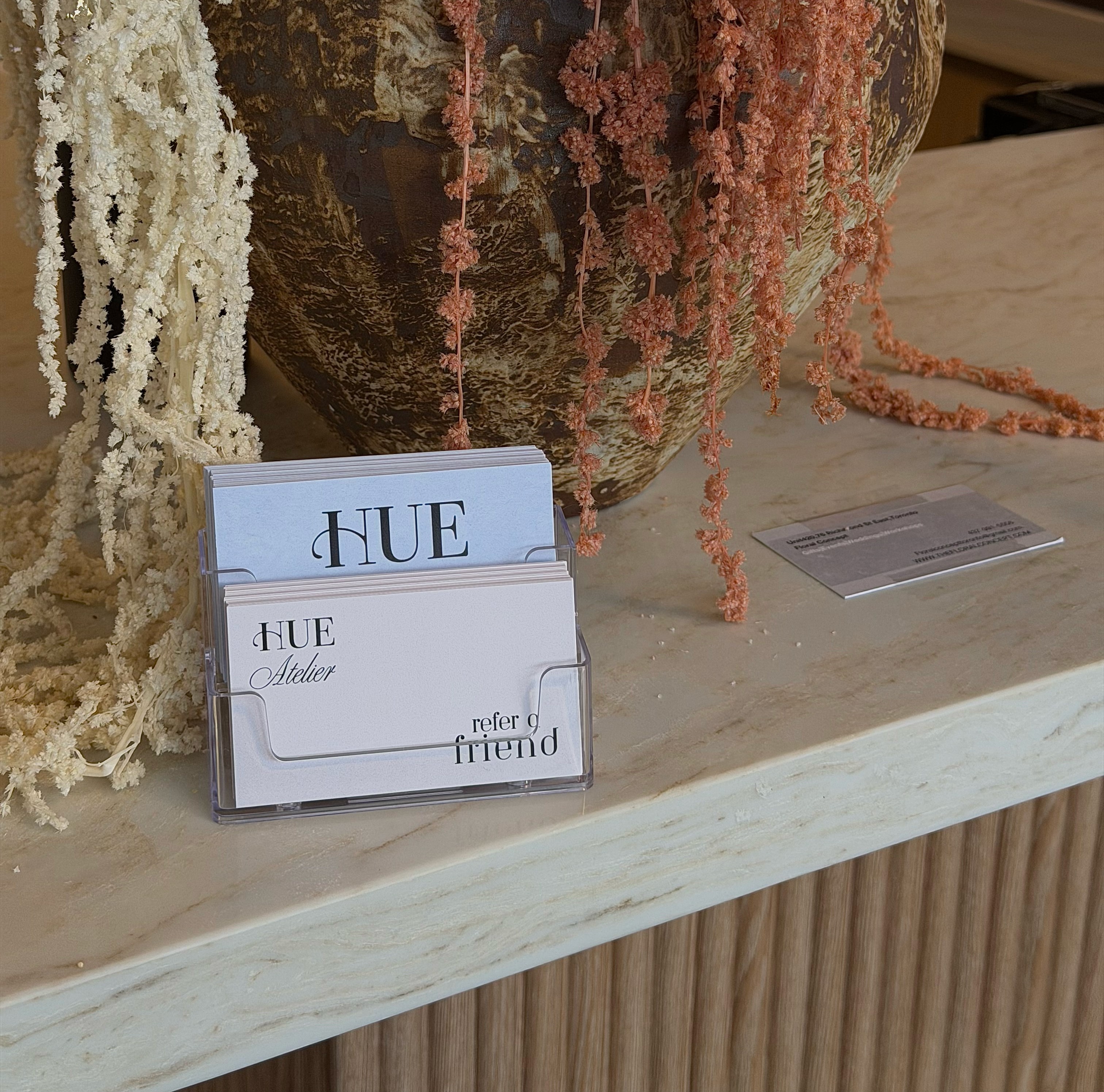 A luxurious indoor pool area with a panoramic view of a city at sunset. Comfortable lounge beds with soft fabrics surround the pool, while warm ambient lighting enhances the sophisticated atmosphere. The space combines modern elegance with a tranquil vibe.