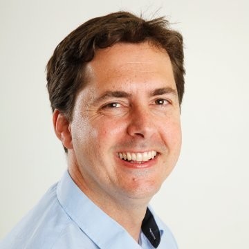 man in gray polo shirt smiling