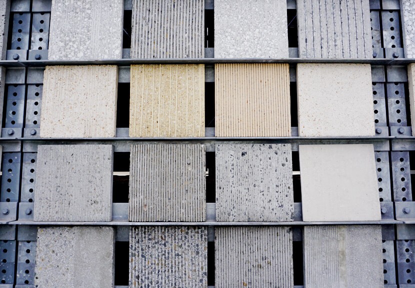 A selection of stone tiles with various textures and finishes, displayed in a metal framework for comparison.