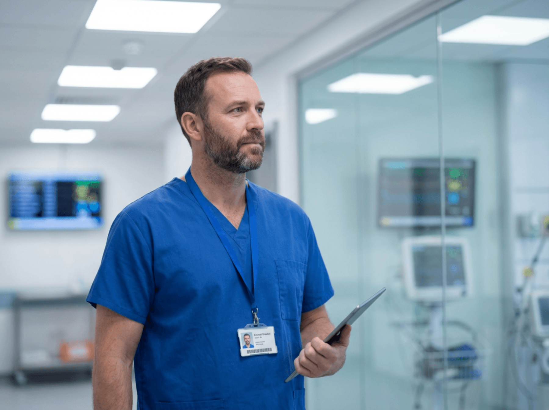 Clinical director holding a tablet in a modern hospital corridor